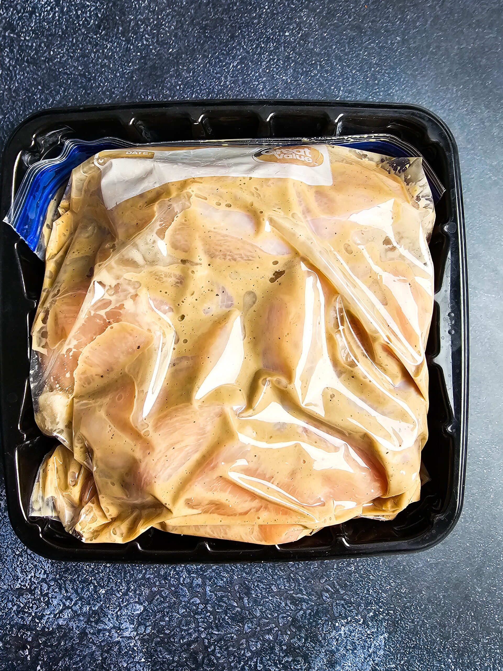 Chicken cutlets marinating in ranch dressing, Worcestershire sauce, lemon juice and garlic in a zip-lock bag