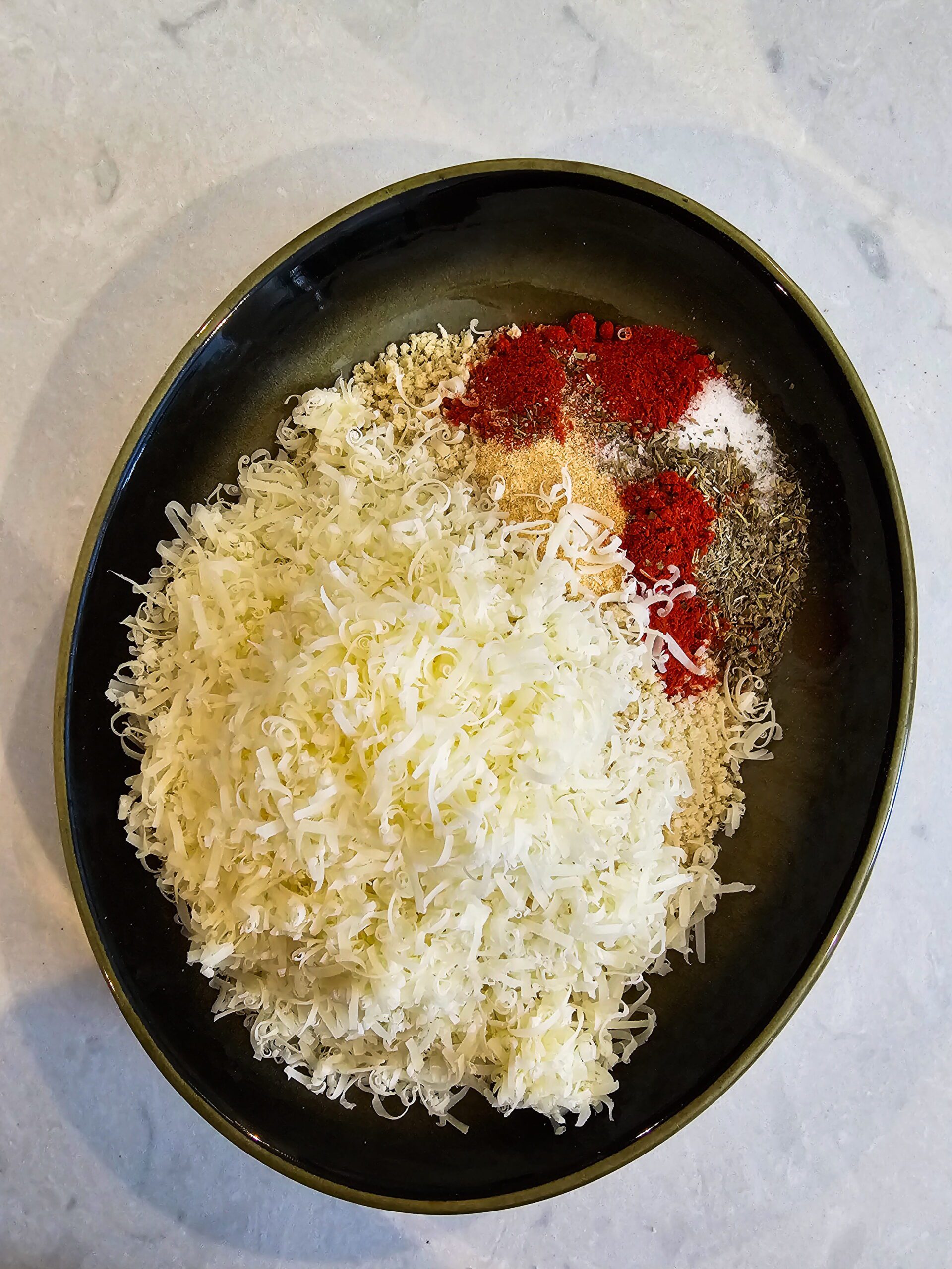 Three-bowl breading station with flour, egg wash, and panko parmesan mixture for crispy chicken cutlets