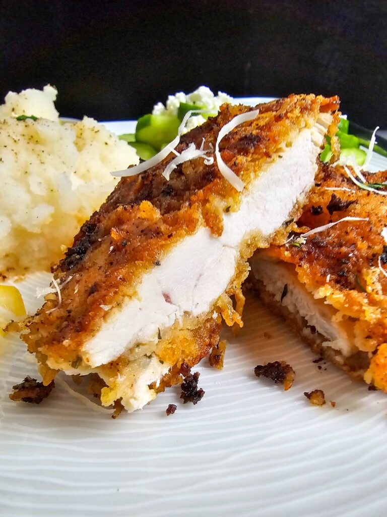 Juicy ranch parmesan chicken cutlet sliced open showing tender interior with crispy crust