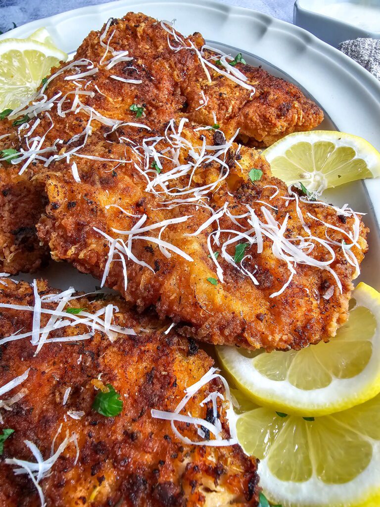 Golden crispy ranch parmesan chicken cutlets stacked and ready to serve