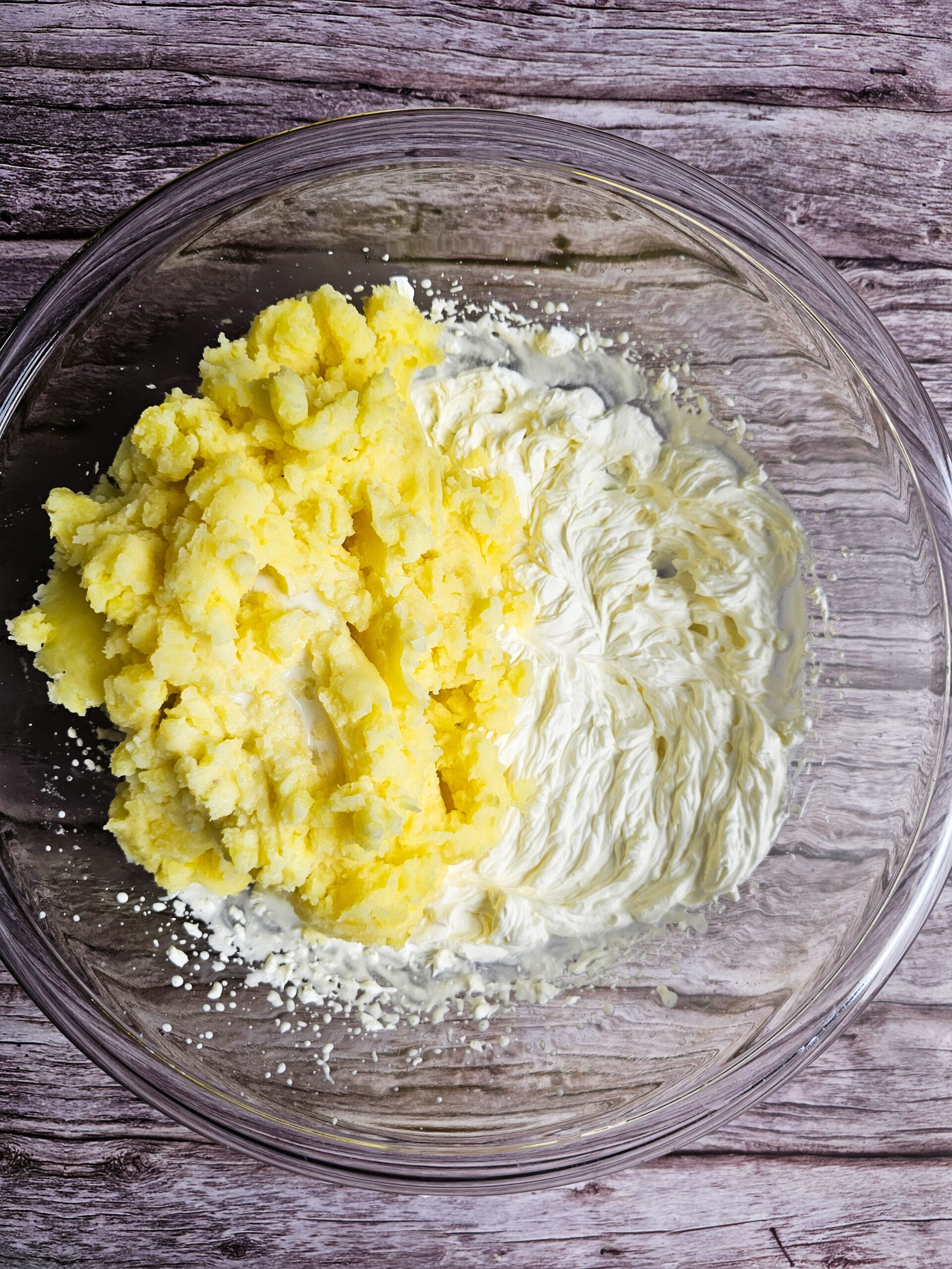 Whipped cream being folded into mashed potatoes to create light airy Chantilly texture