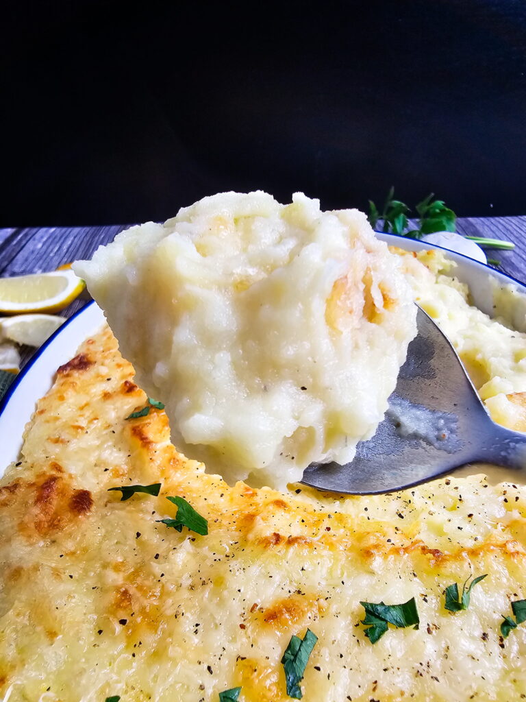 Chantilly mashed potatoes in a casserole dish with golden cheese topping