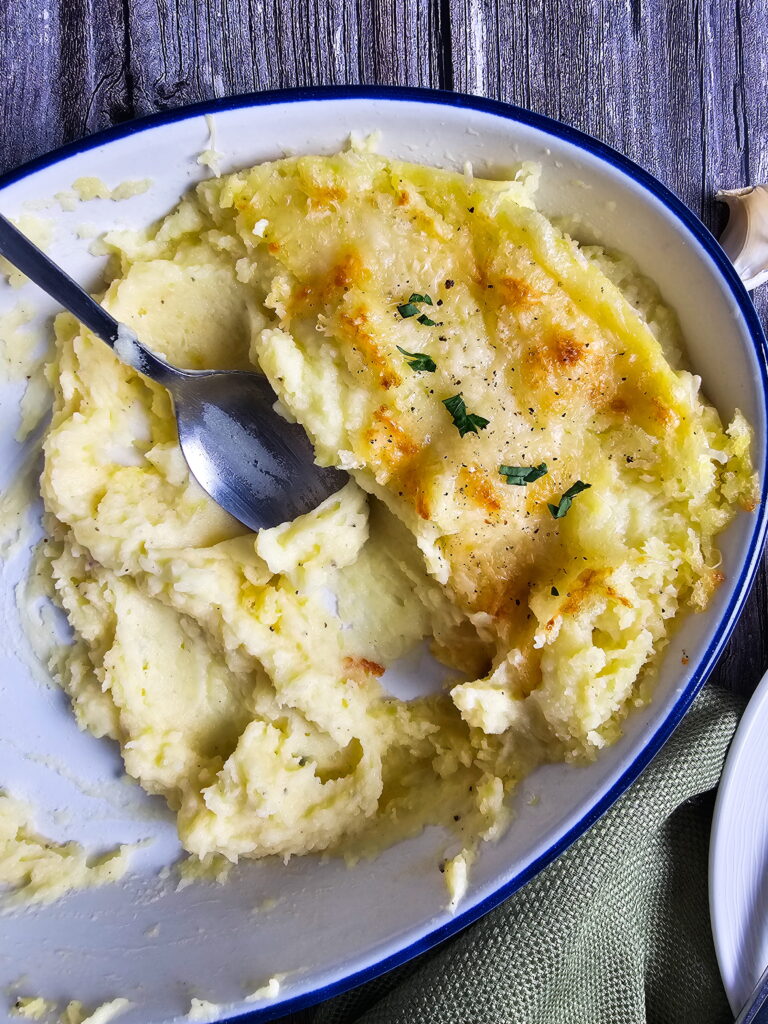 Golden Chantilly mashed potatoes in a casserole dish ready to serve at a holiday dinner