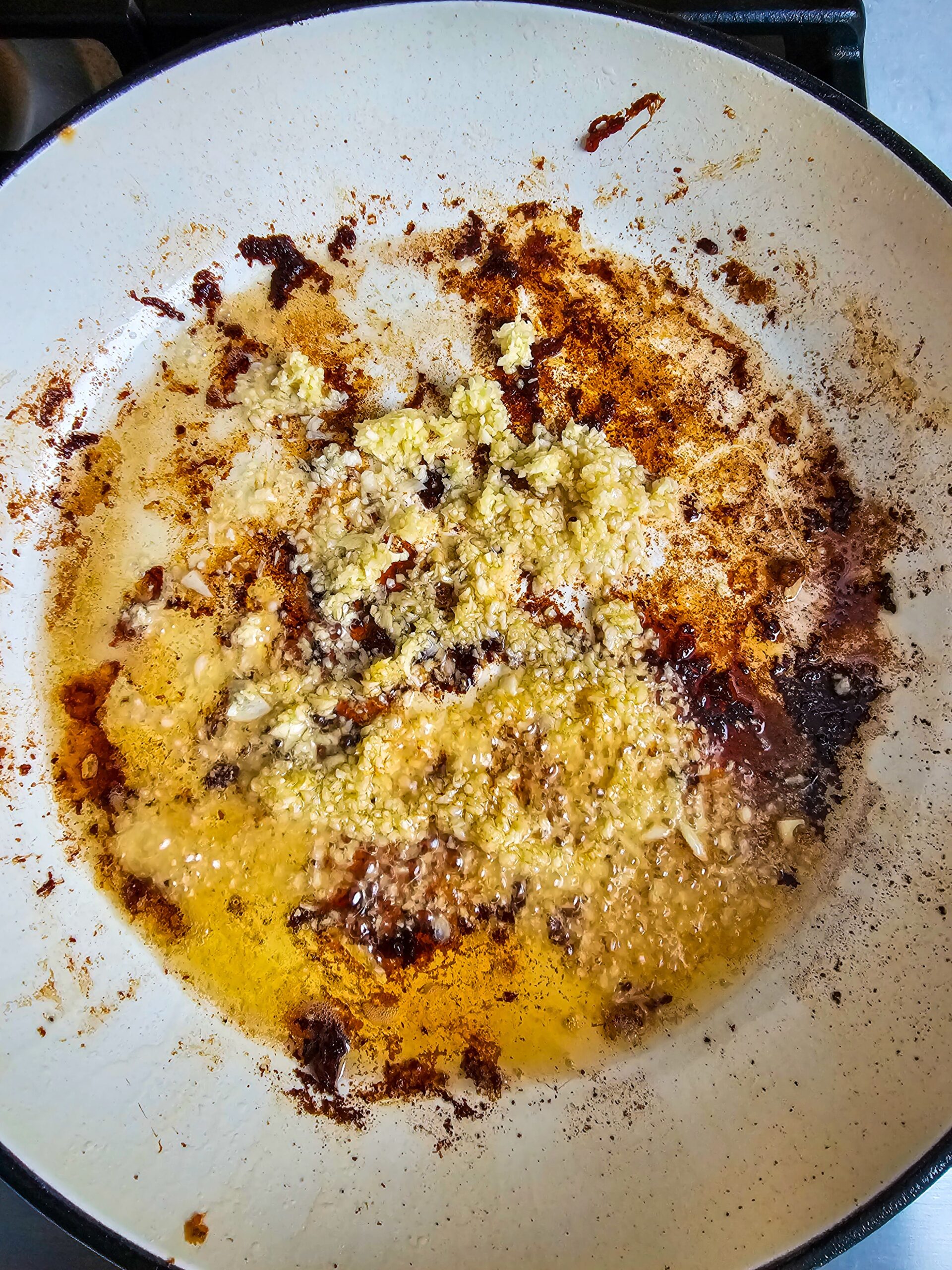 adding minced garlic and spices to the skillet