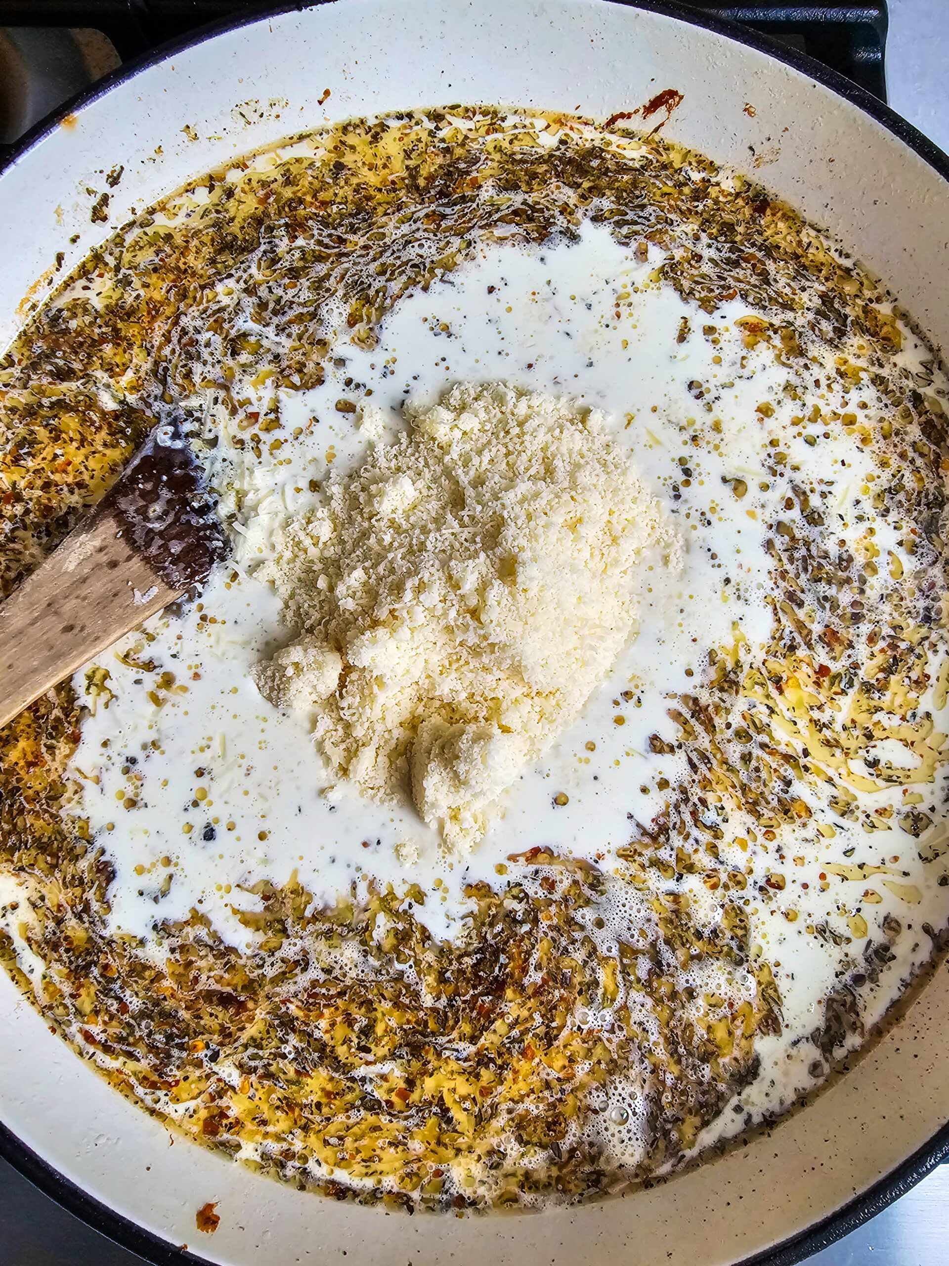 ADDING THE CHICKEN STOCK, HEAVY WHIP AND PARMESAN CHEESE