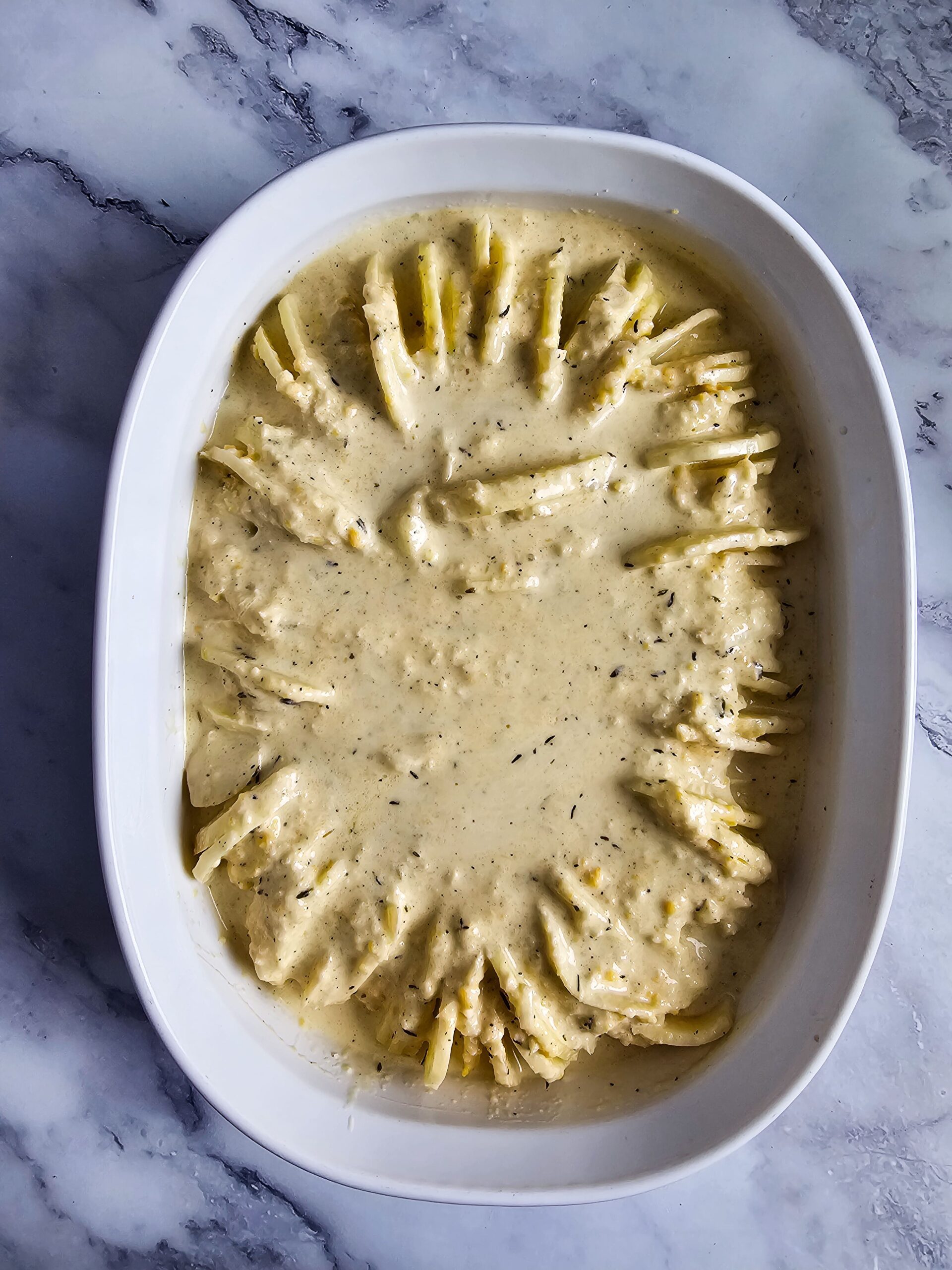 POUR THE LEFTOVER CHEESE SAUCE OVER THE POTATOES, COVER, AND BAKE