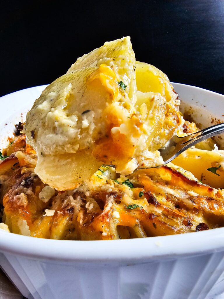 SERVING SPOON FULL OF CHEESY POTATOES AU GRATIN