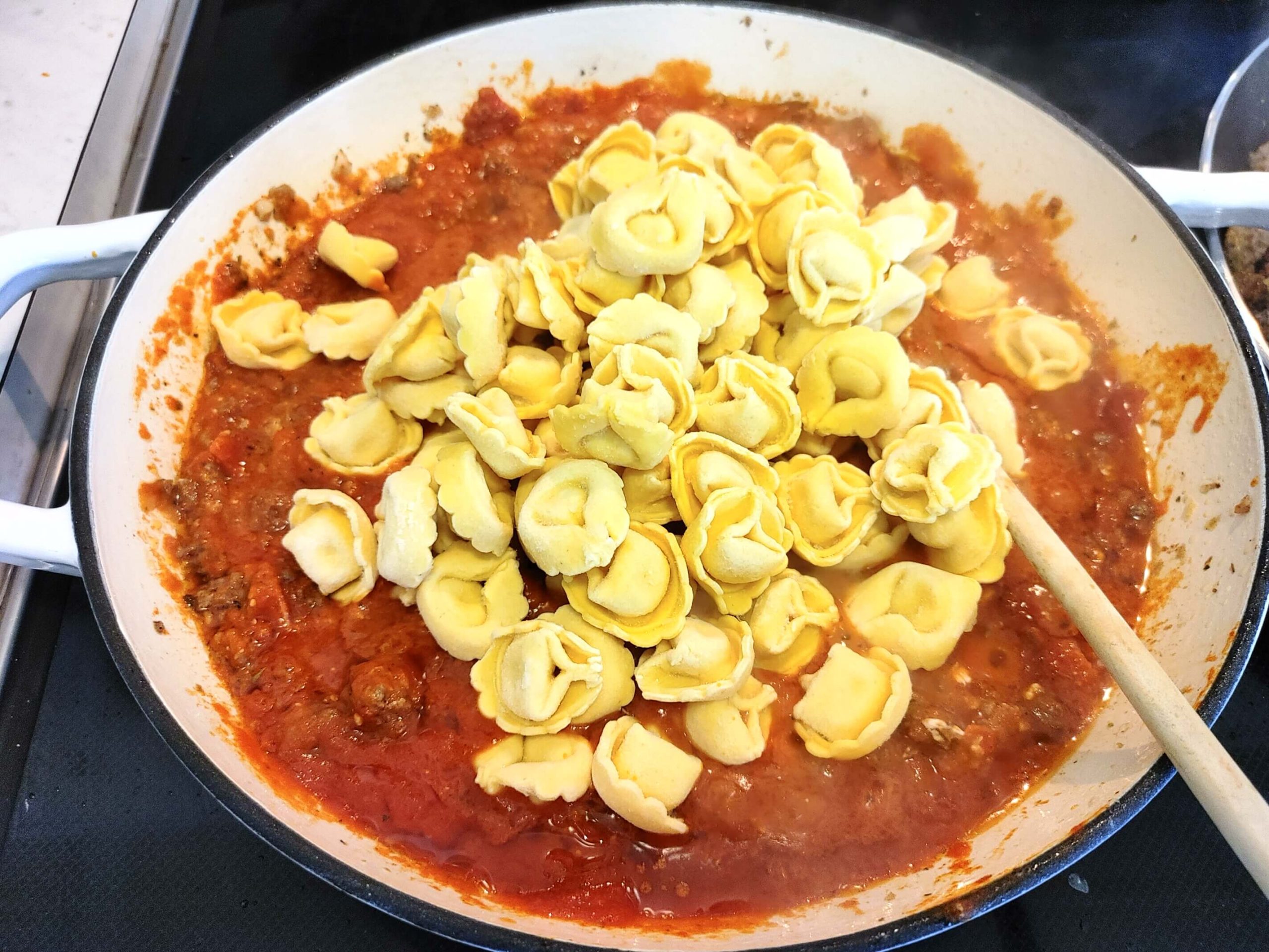 ADDING IN CREAM CHEESE, MARINARA SAUCE AND TORTELLINI