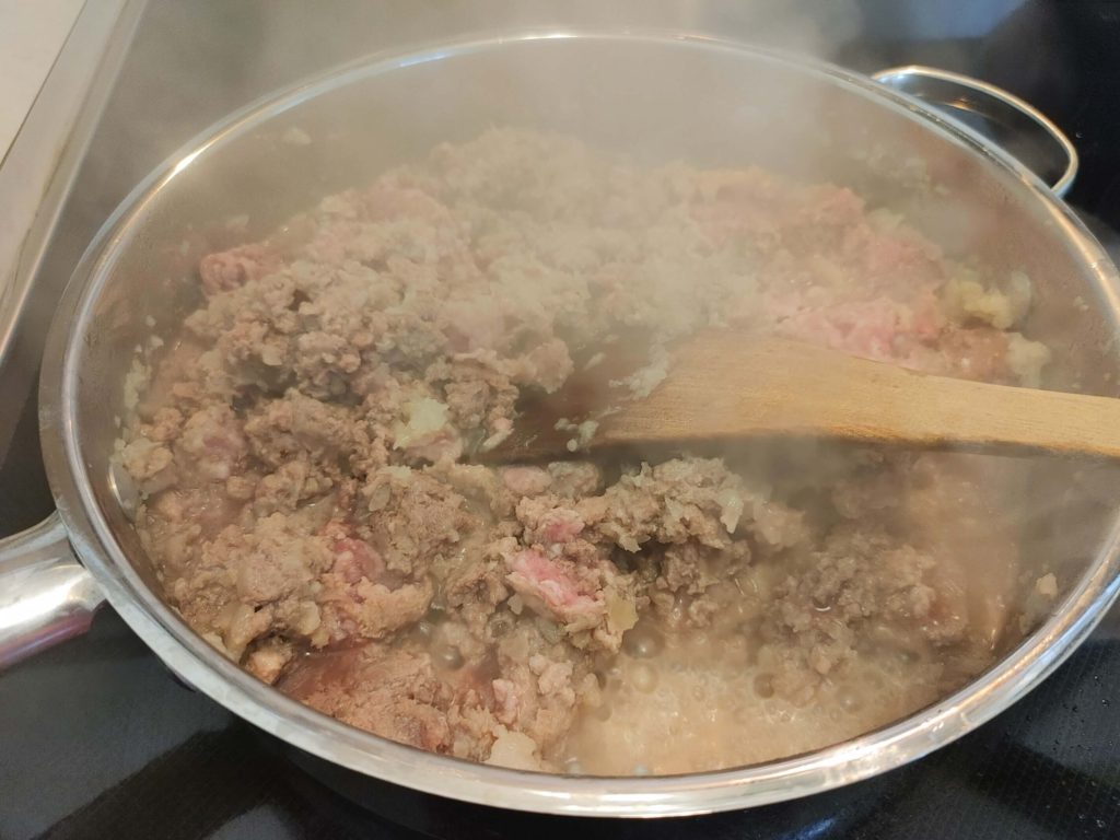 ADDING BEEF AND PORK TO THE SKILLET