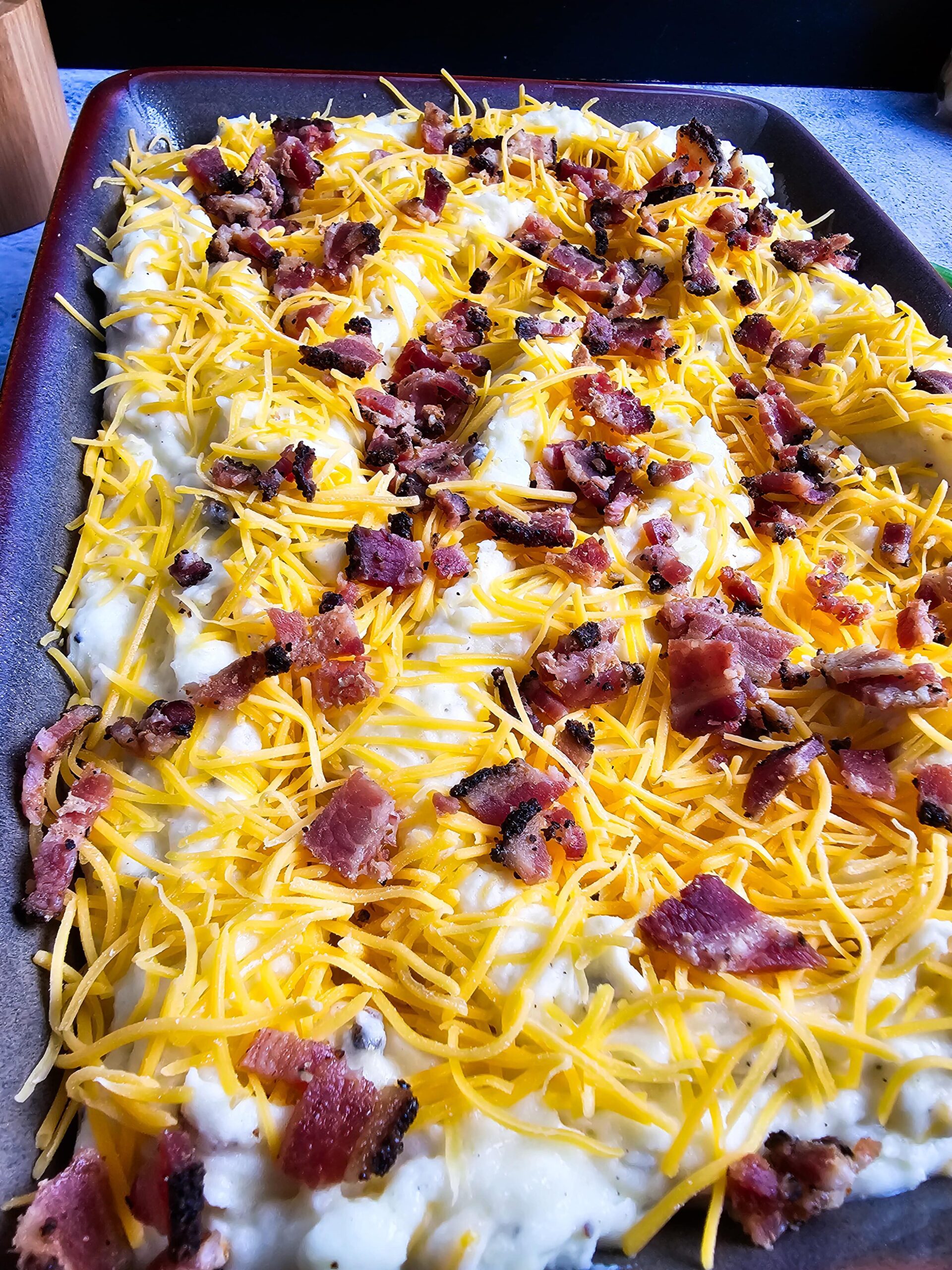 TRANSFER TO 9X13 BAKING DISH ADD SHREDDED CHEESE AND BACON ON TOP