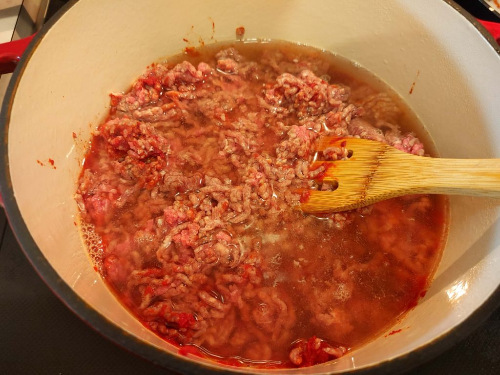 BEGIN COOKING THE TOMATO PASTE BEEF AND CHICKEN STOCK