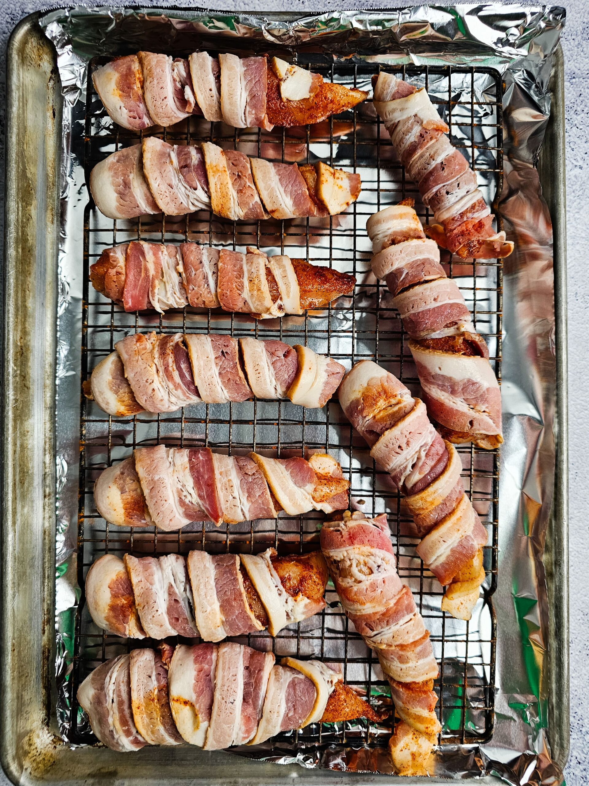 WRAP THE SEASONED TENDERED WITH BACON AND PLACE ON WIRE RACK