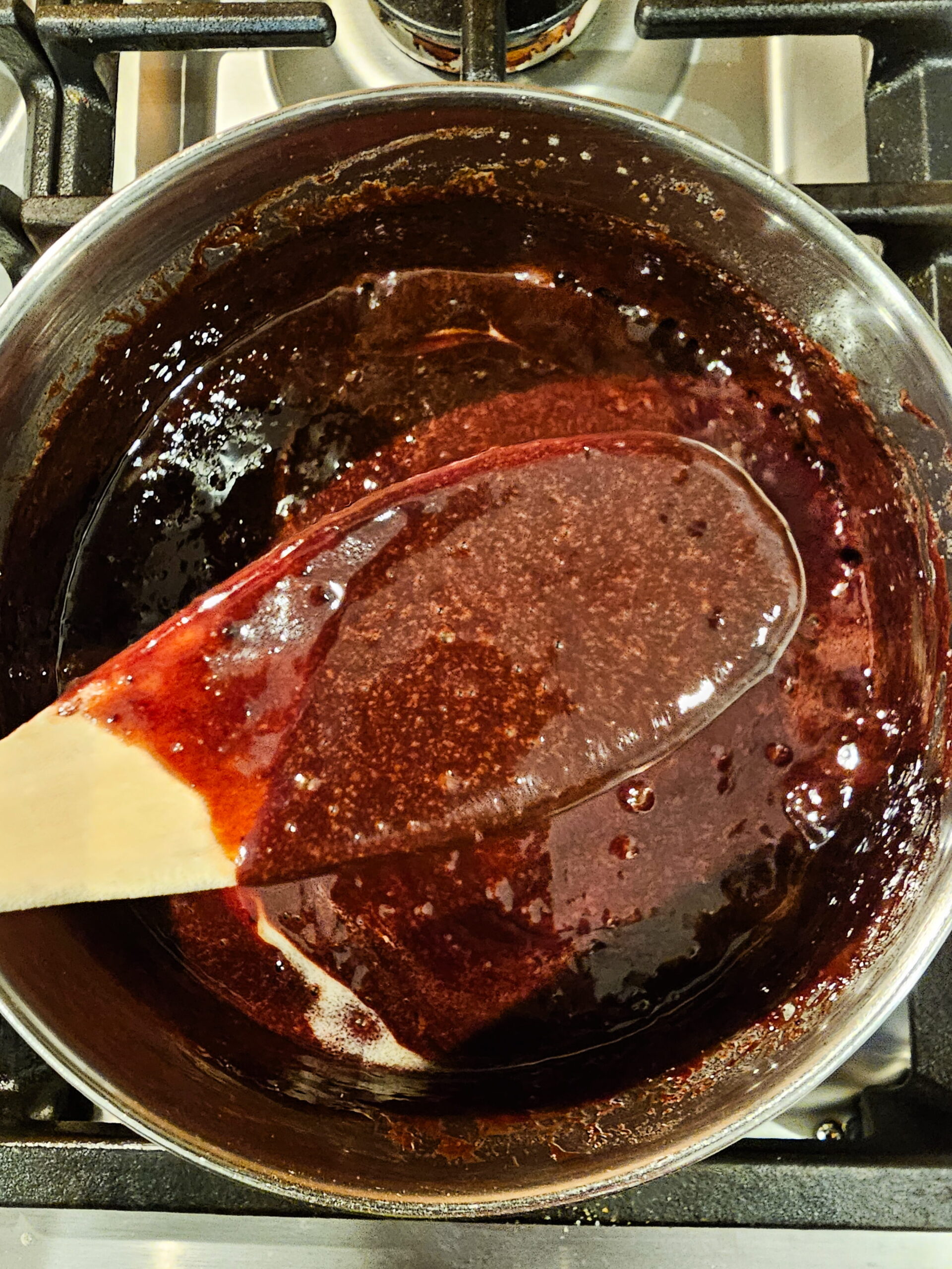 Homemade chocolate fudge topping simmering in a saucepan for no-bake eclair cake