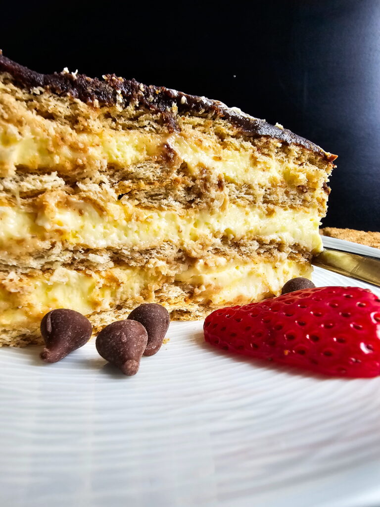 No-bake chocolate eclair cake for a crowd in a 14x11 lasagna pan ready to serve with glossy homemade chocolate fudge topping