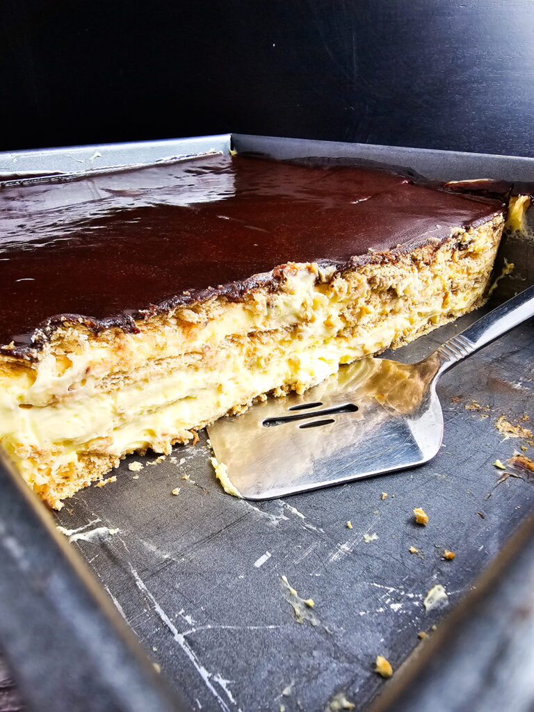 Layering graham crackers and vanilla pudding filling in a 14x11 lasagna pan for large-batch eclair cake