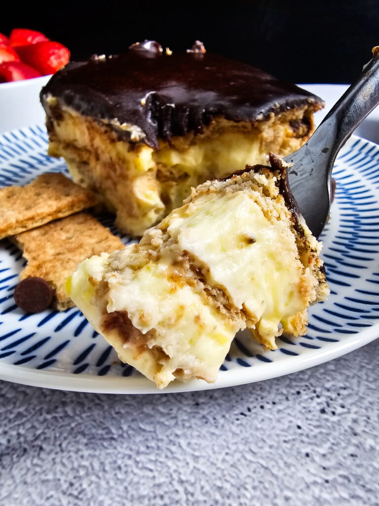 Homemade stovetop chocolate fudge topping for eclair cake being cooked in a saucepan with cocoa butter sugar and milk