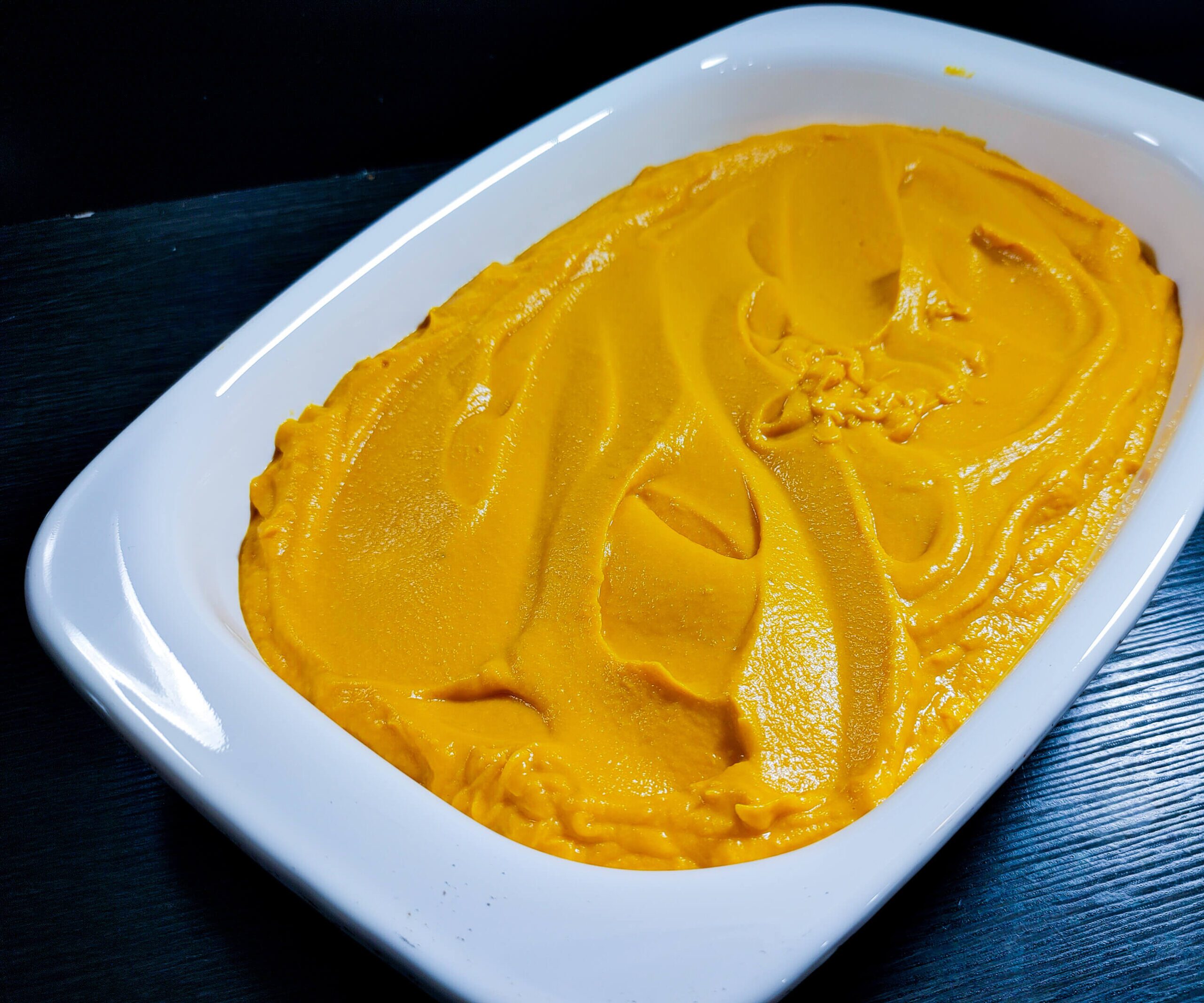 casserole dish with the sweet potato filling smoothed