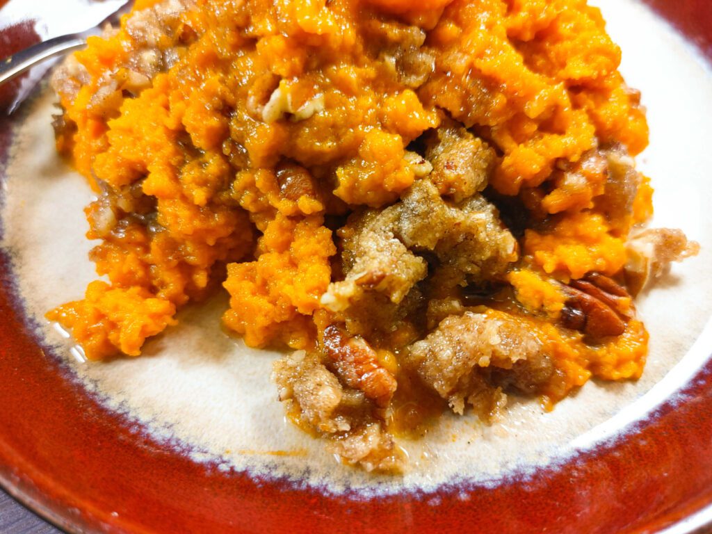 UPCLOSE PHOTO OF THE BAKED SWEET POTATO CASSERLE WITH THE CRISP PECAN TOPPING YUM