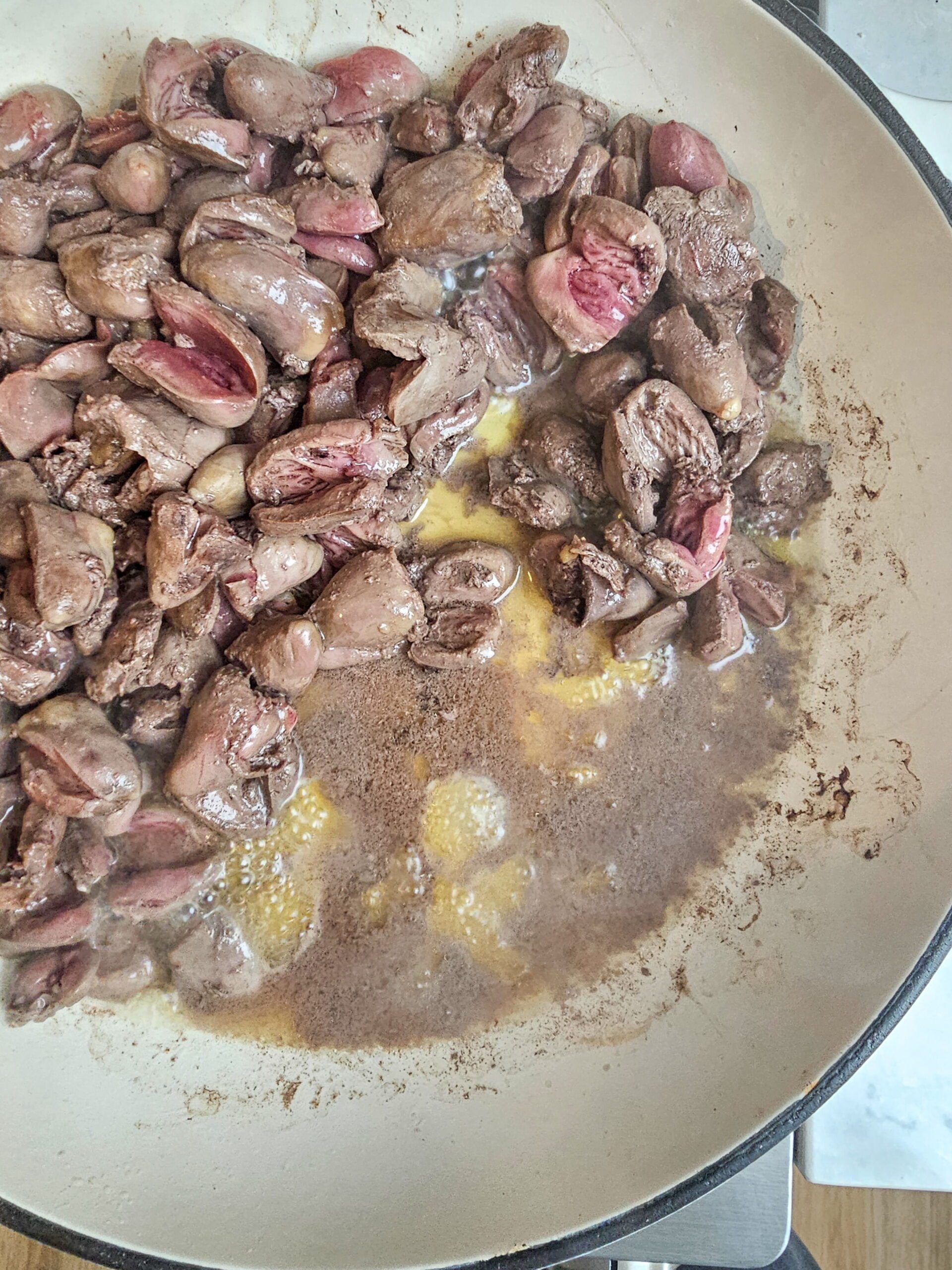  chicken hearts releasing liquid in a dry skillet during first stage of sauteing