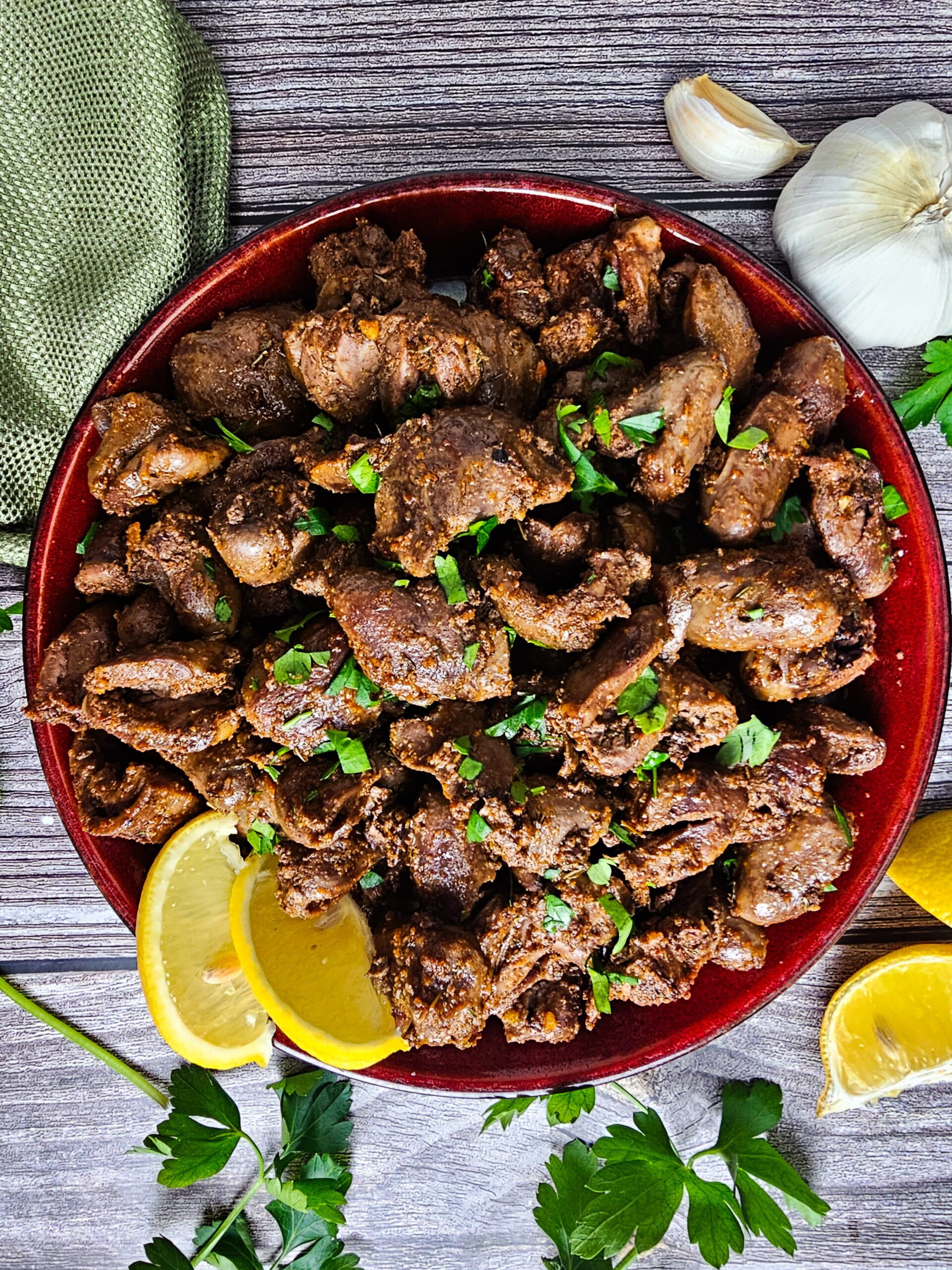  finished sauteed chicken hearts plated with fresh parsley garnish ready to serve