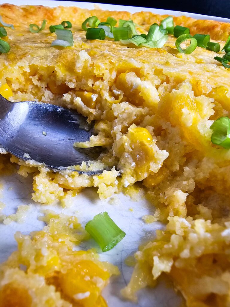 UP CLOSE PHOTO OF THE CORN CASSEROLE WHERE THE CASSEROLE WAS SCOOPED OUT