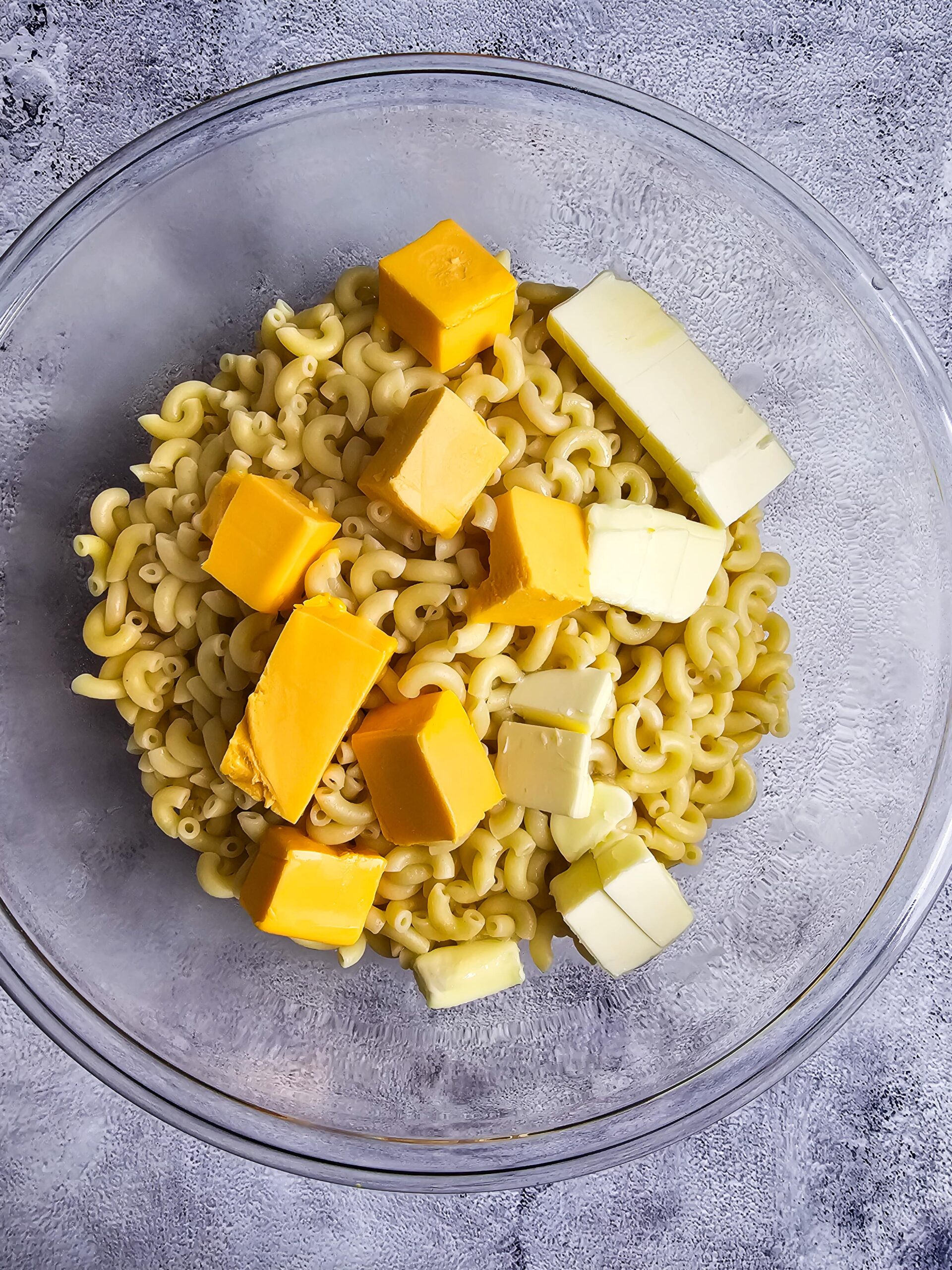 add the butter and velveta to the hot noodles to melt the cheese.