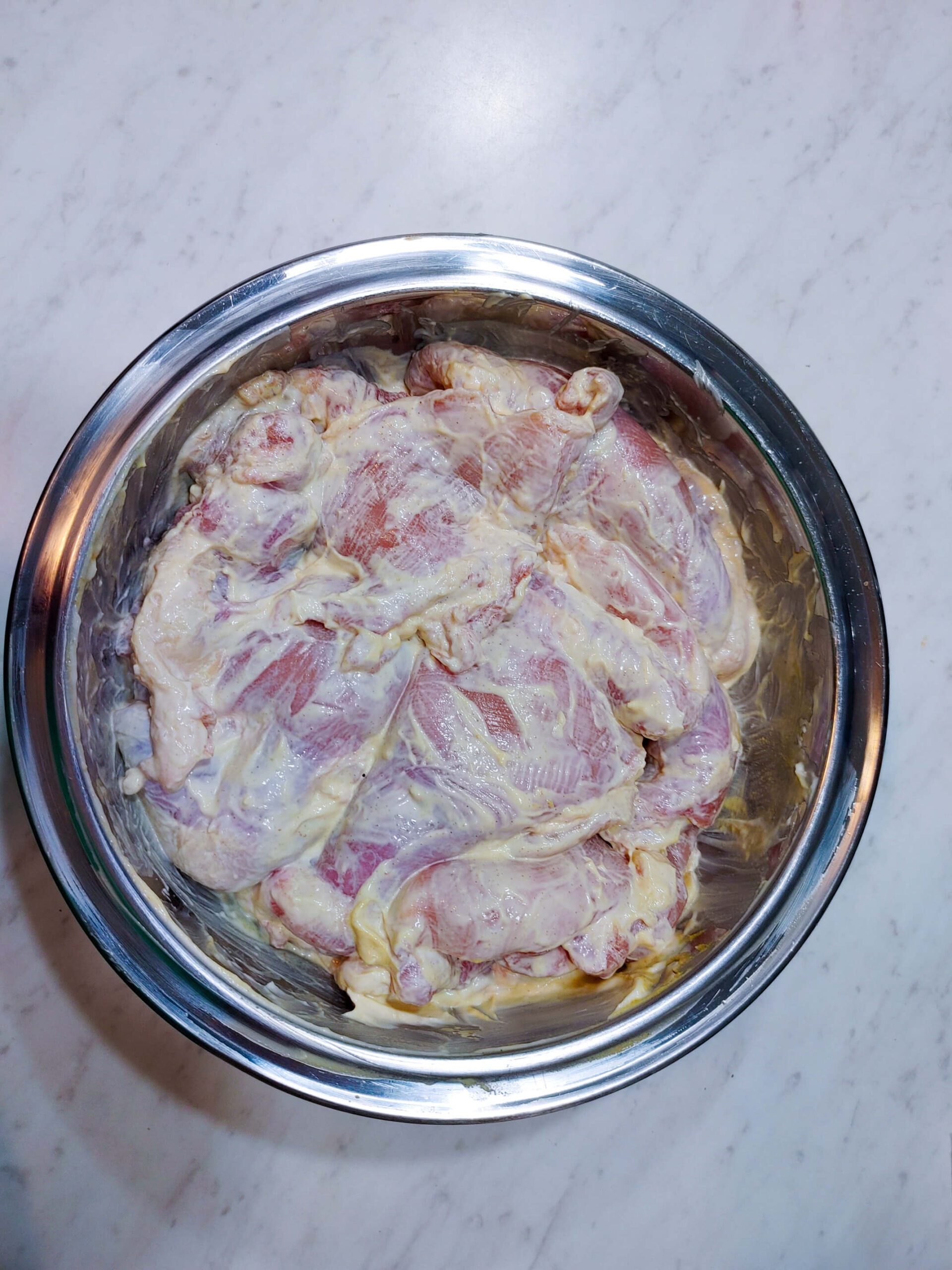 chicken thighs coated in mayonnaise and Dijon mustard binder for panko breading