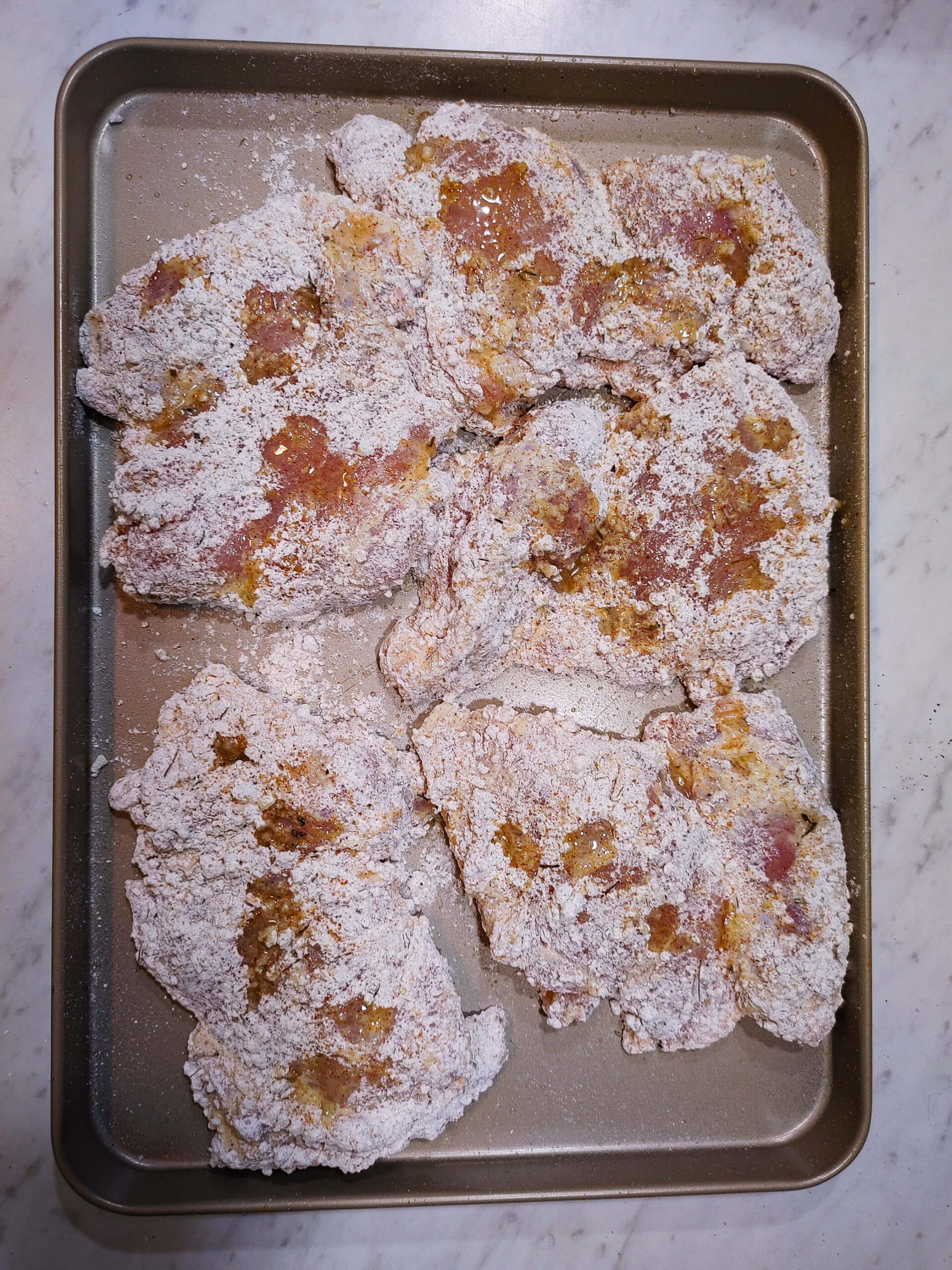 boneless chicken thigh pressed firmly into seasoned panko breadcrumb crust mixture