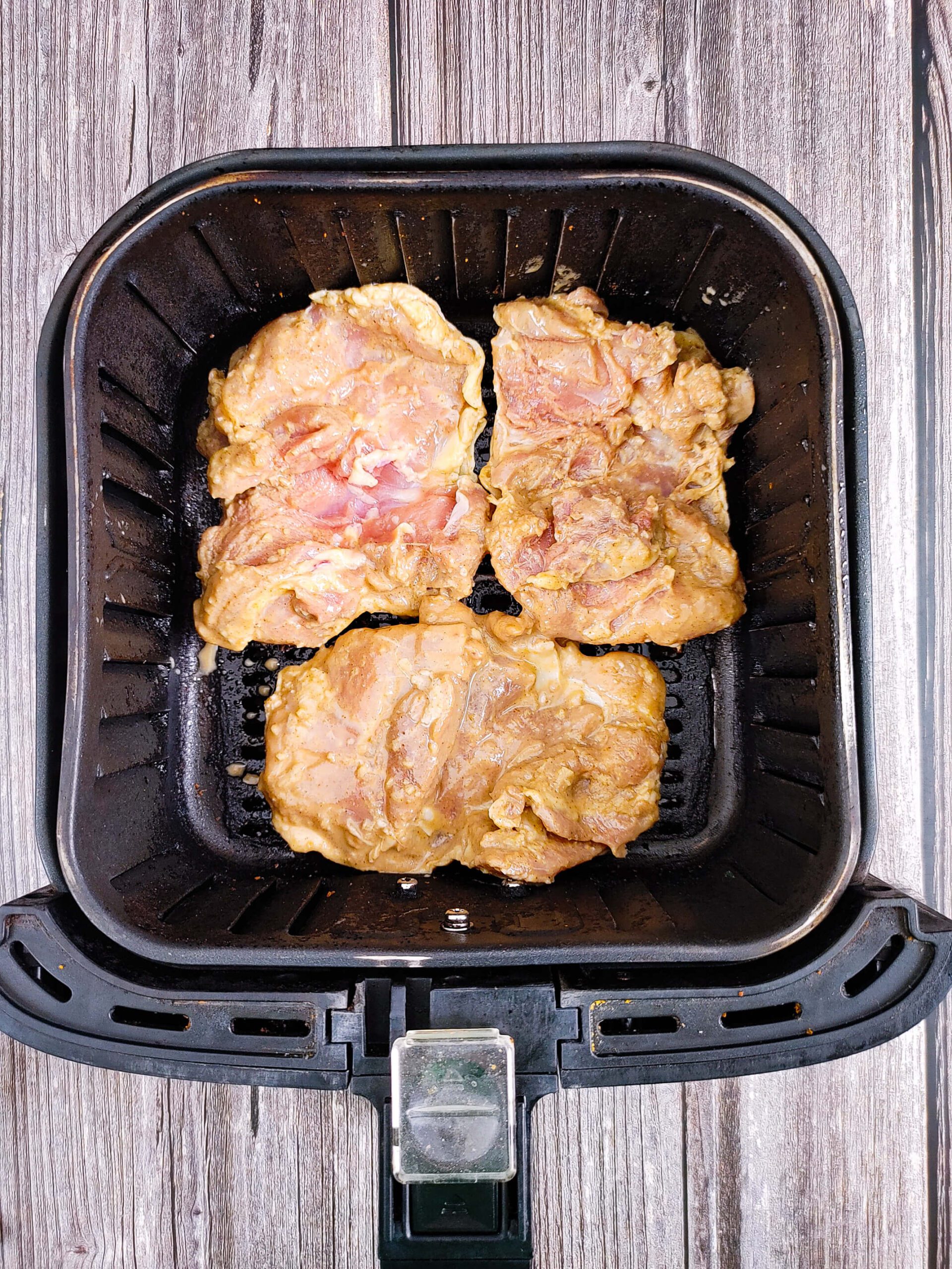 bone-in skin-on chicken thighs placed skin side down in air fryer basket single layer