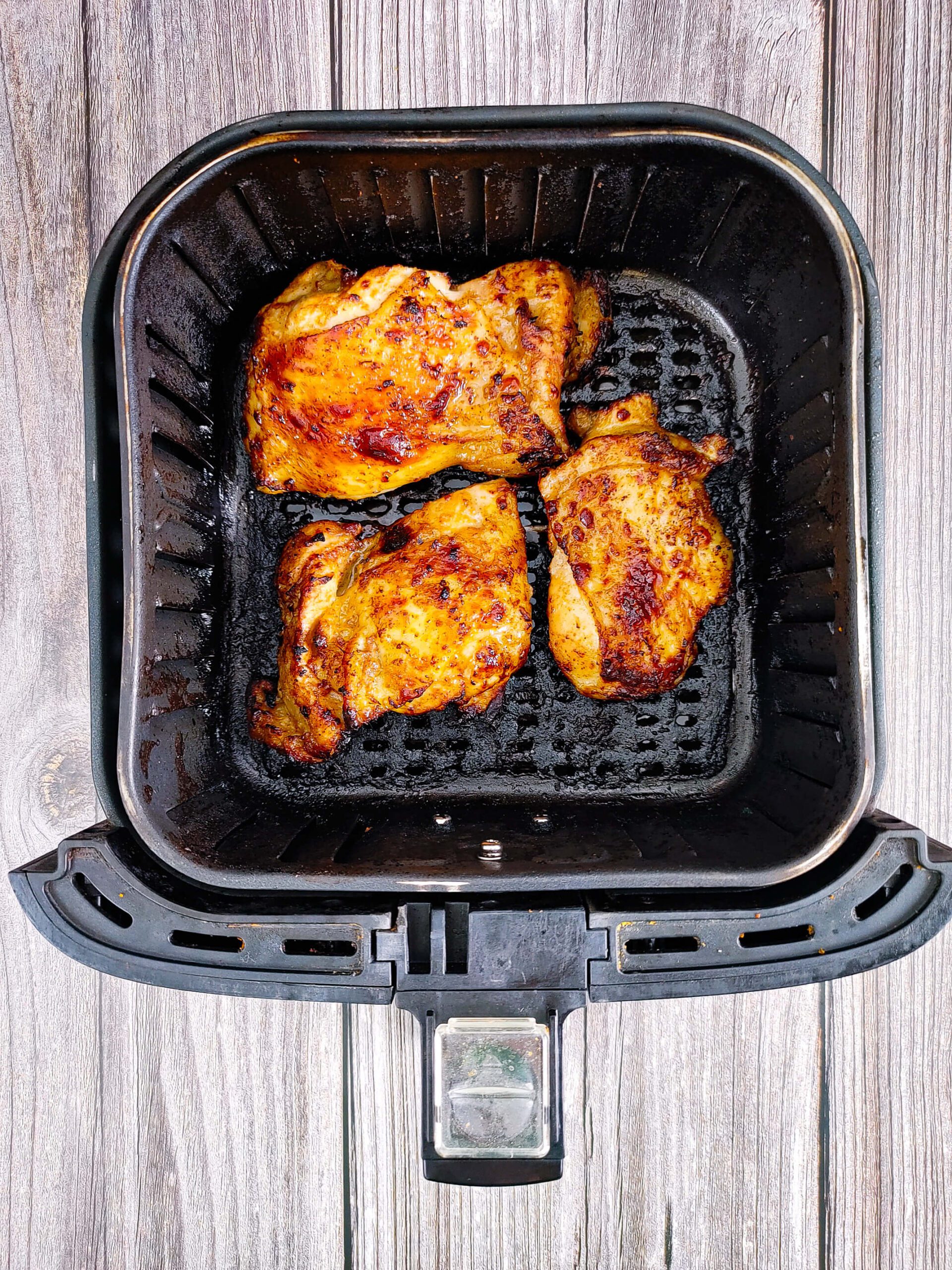 instant read thermometer inserted in bone-in air fryer chicken thigh reading 165 degrees F