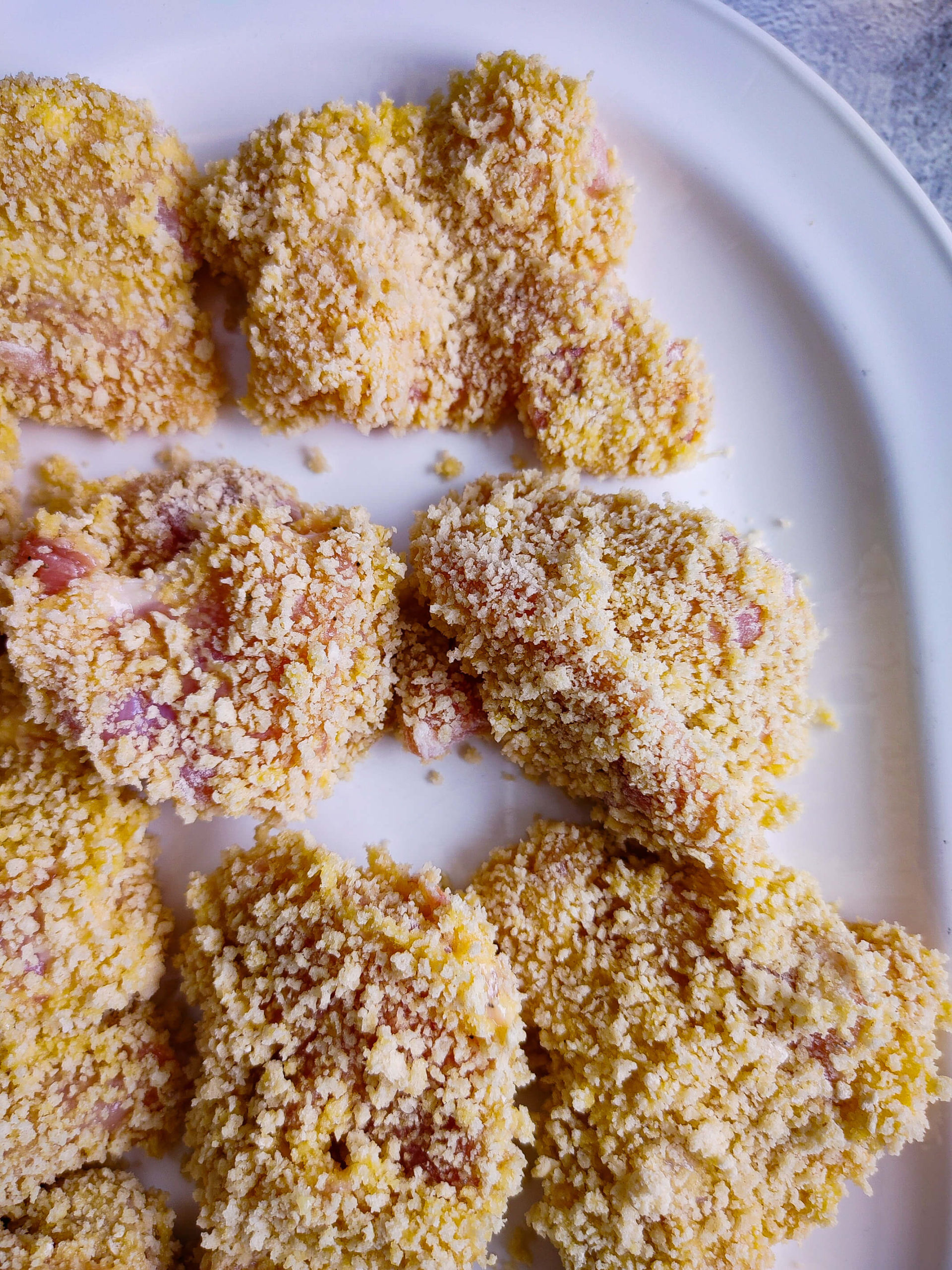 DREDGE THE CHICKEN BITES INTO THE FLOUR, EGG, AND PANKO