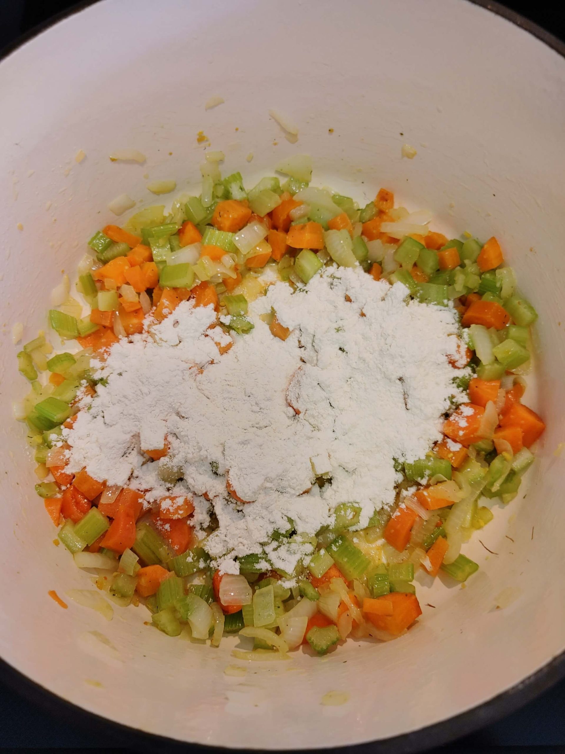 ADD FLOUR TO THE ONION, CARROTS, AND CELERY