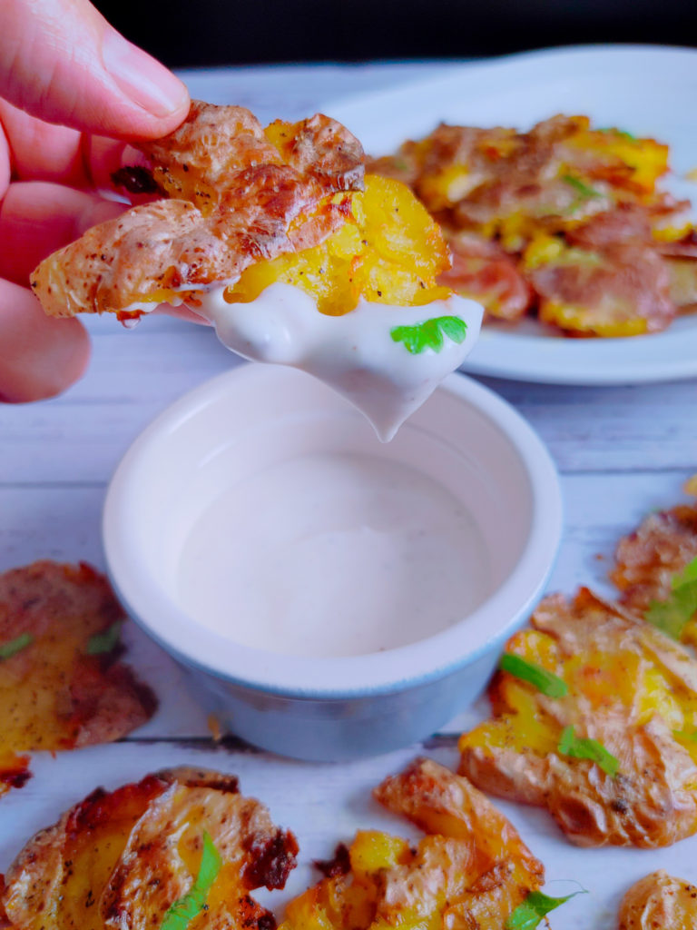 DIPPING THE SMASHED POTATOES IN YOUR FAVORITE SAUCES