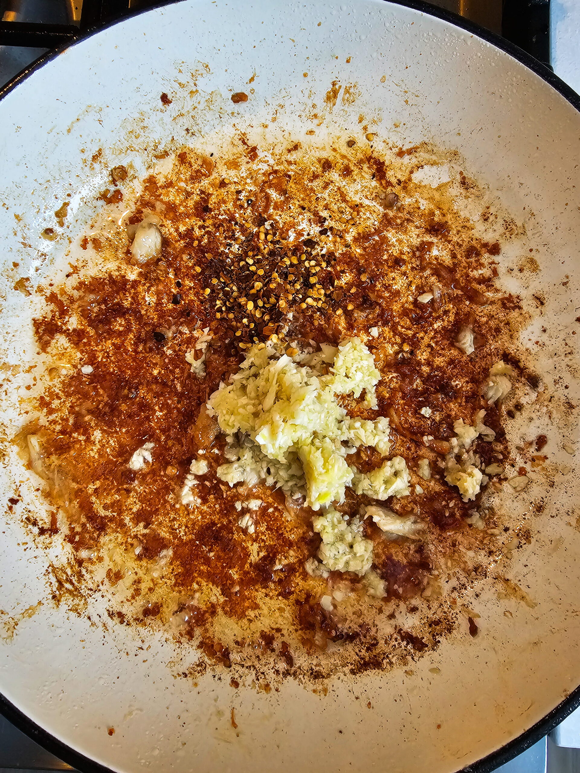 Garlic ginger and red pepper flakes sautéing in pan for flavorful Mongolian chicken sauce base.