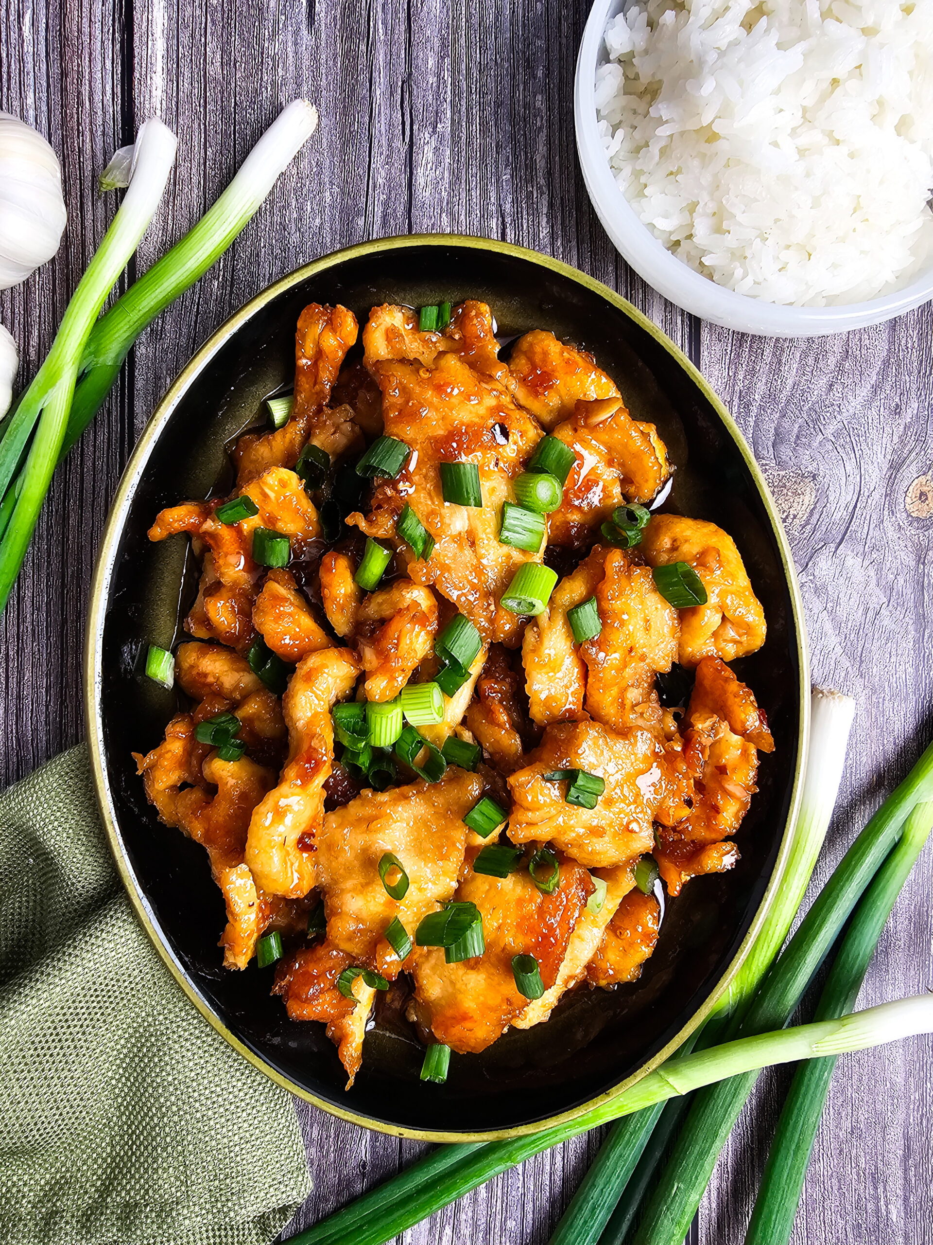 Close up of sticky Mongolian chicken with caramelized edges and glossy homemade sauce.