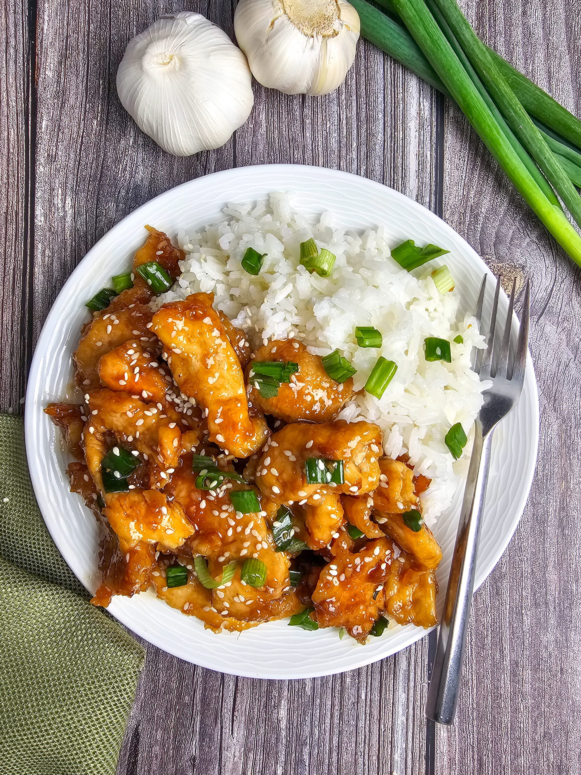 Finished Mongolian chicken topped with green onions and sesame seeds served hot over rice.