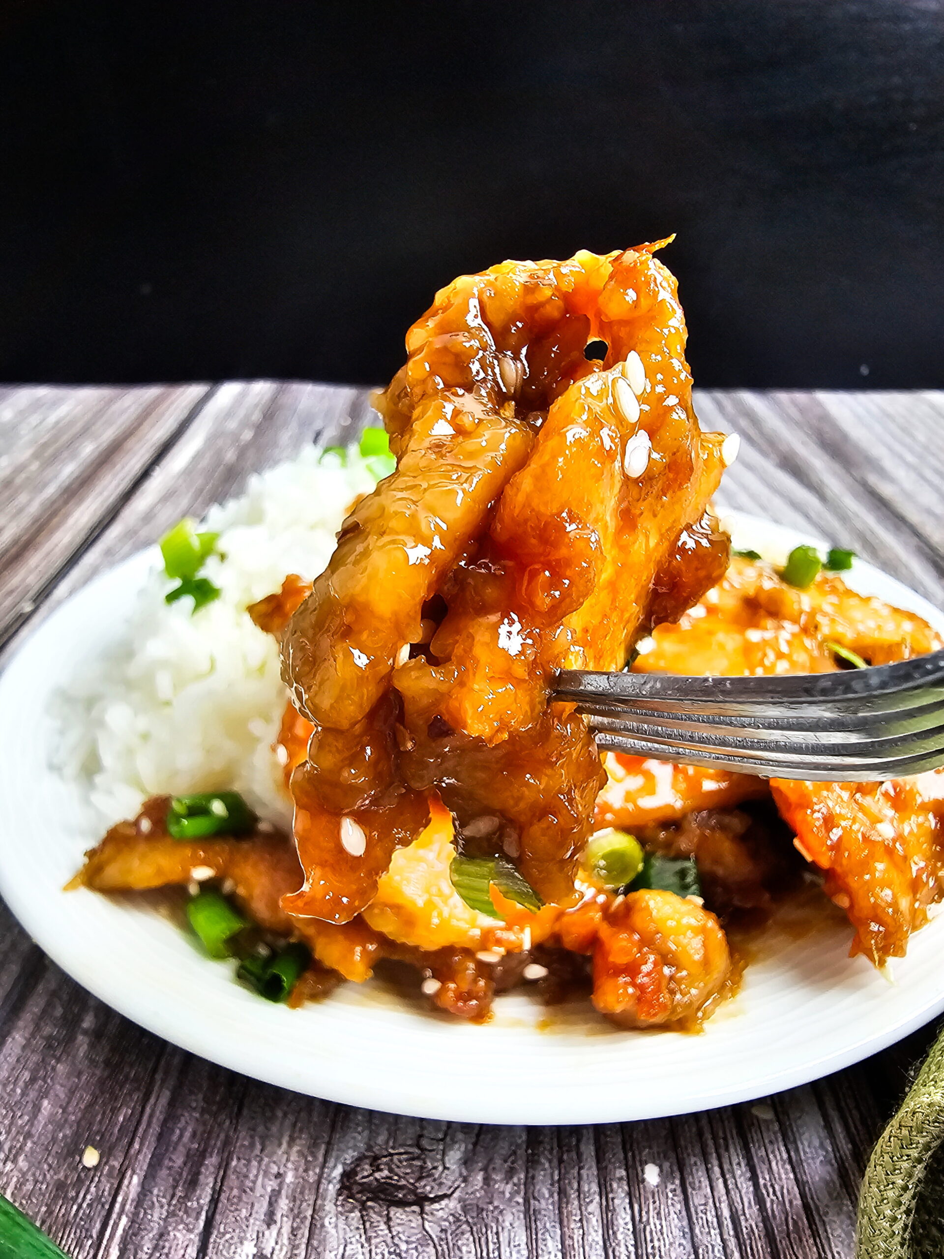 Easy Mongolian chicken dinner served with jasmine rice and garnished with fresh green onions.