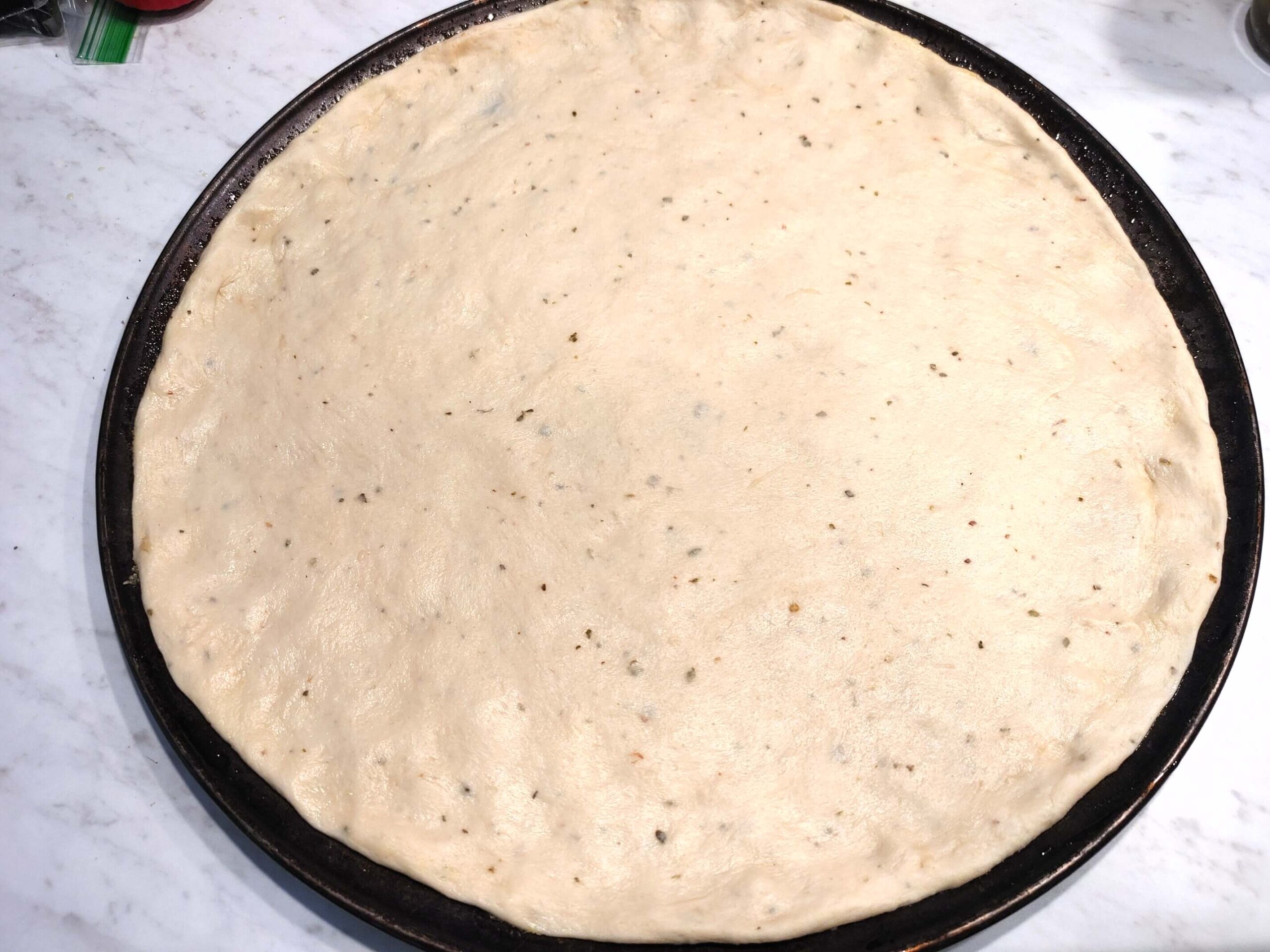 PIZZA DOUGH STRETCHED ON PIZZA PAN