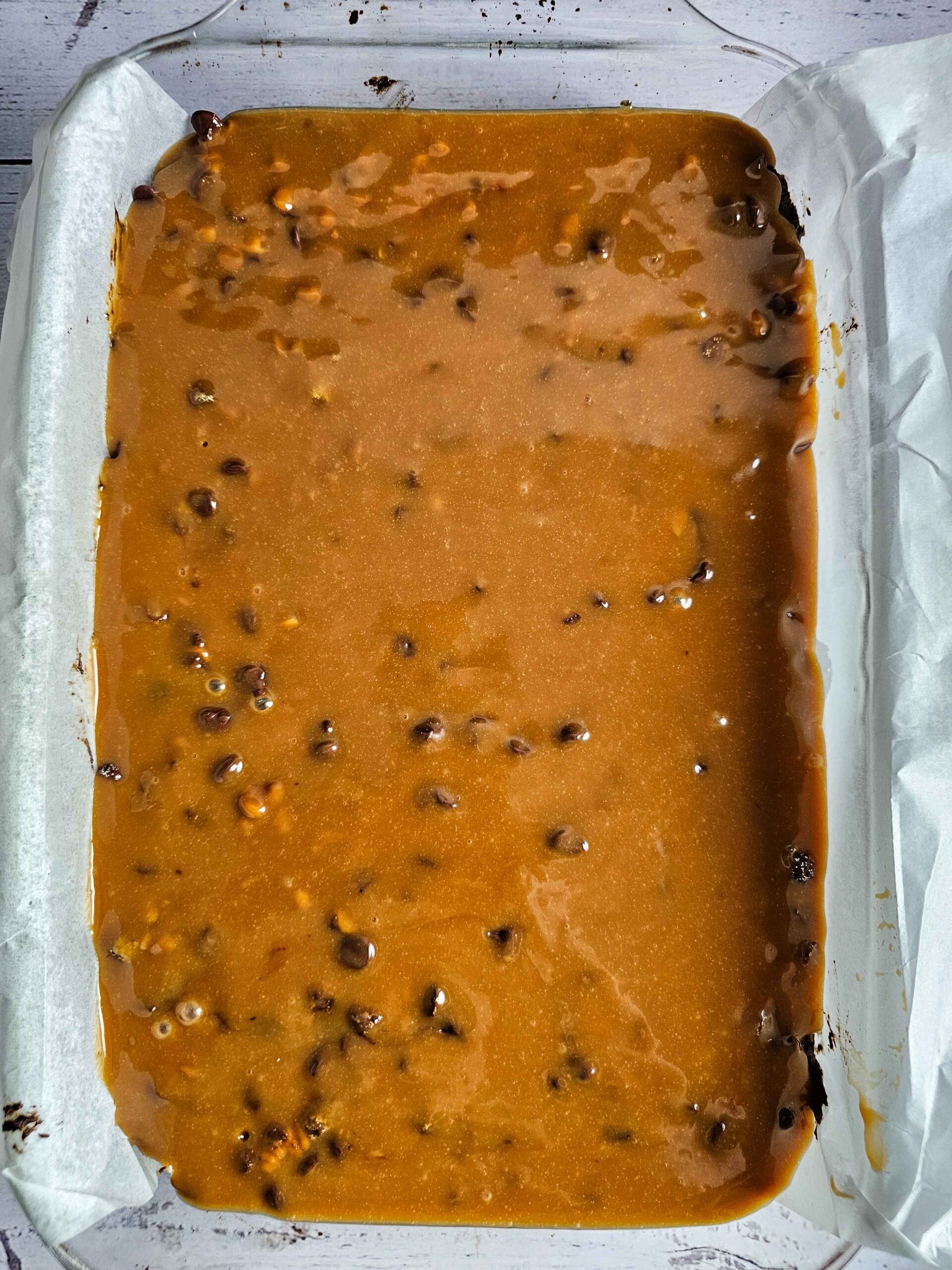 POUR THE CARAMEL LAYER OVER THE PREBAKED BROWNIE LAYER