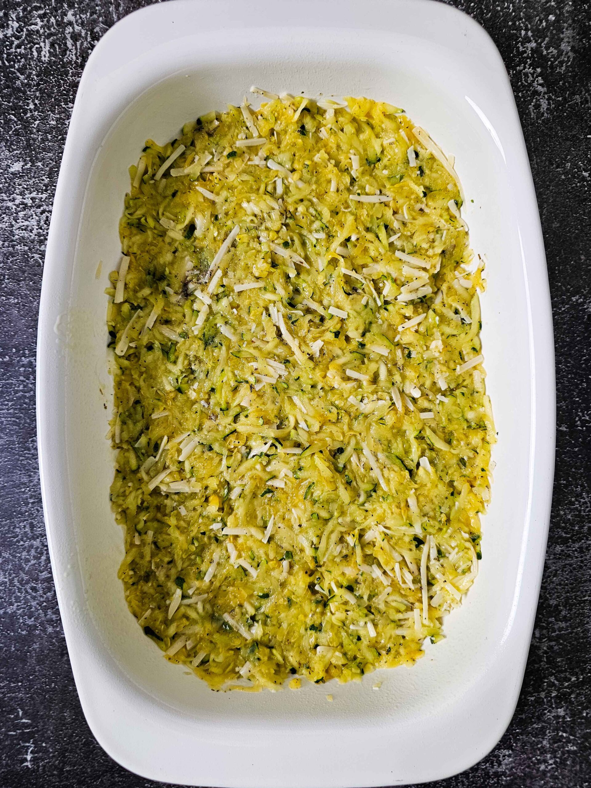 PRESS THE ZUCCHINI CRUST INTO A GREASED 9X13 BAKING DISH