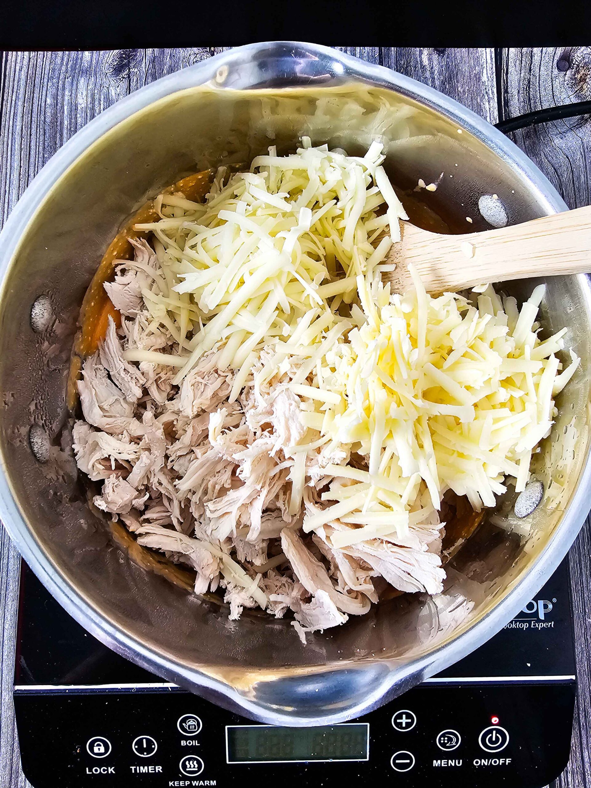 ADD THE SHREDDED CHEESES AND THE SHREDDED CHICKEN TO THE CHEESE SAUCE- STIR TO INCORPORATE