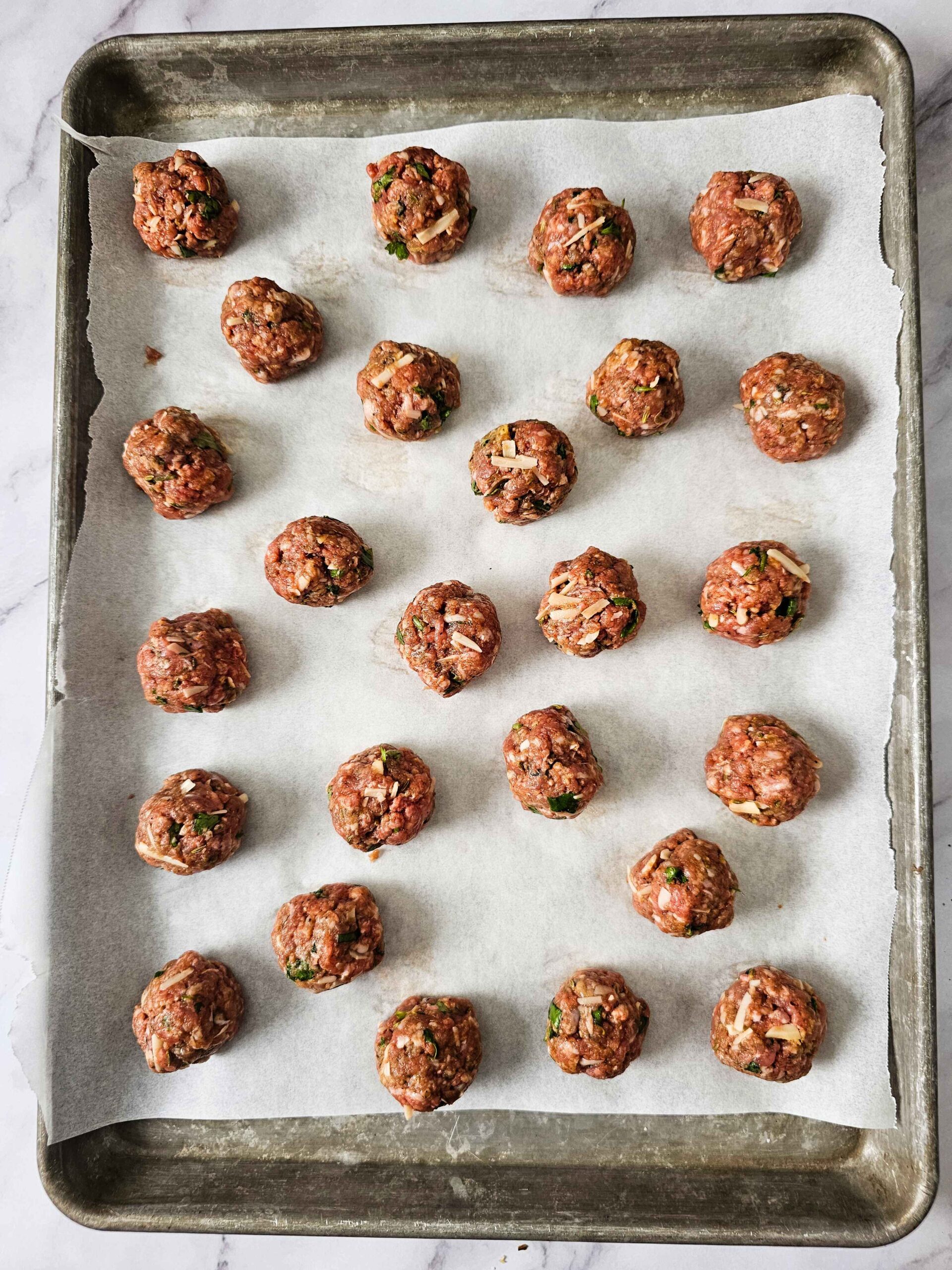 FORM THE MEAT MIXTURE INTO ONE INCH BALLS ARRANGE ON BAKING SHEET