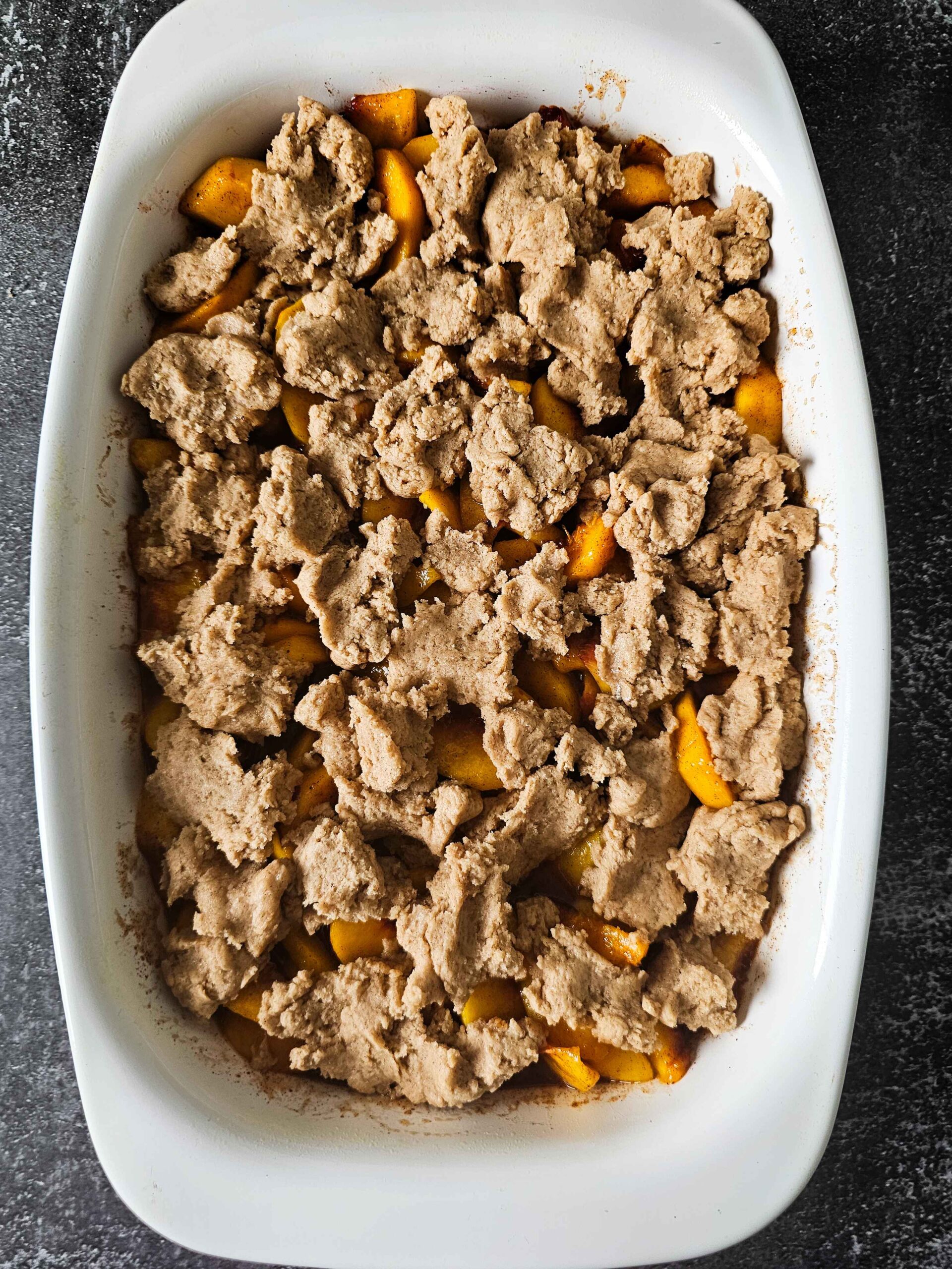 ADD THE COBBLER TOPPING TO THE PEACHES AND RETURN TO OVEN FOR 35 MINUTES MORE