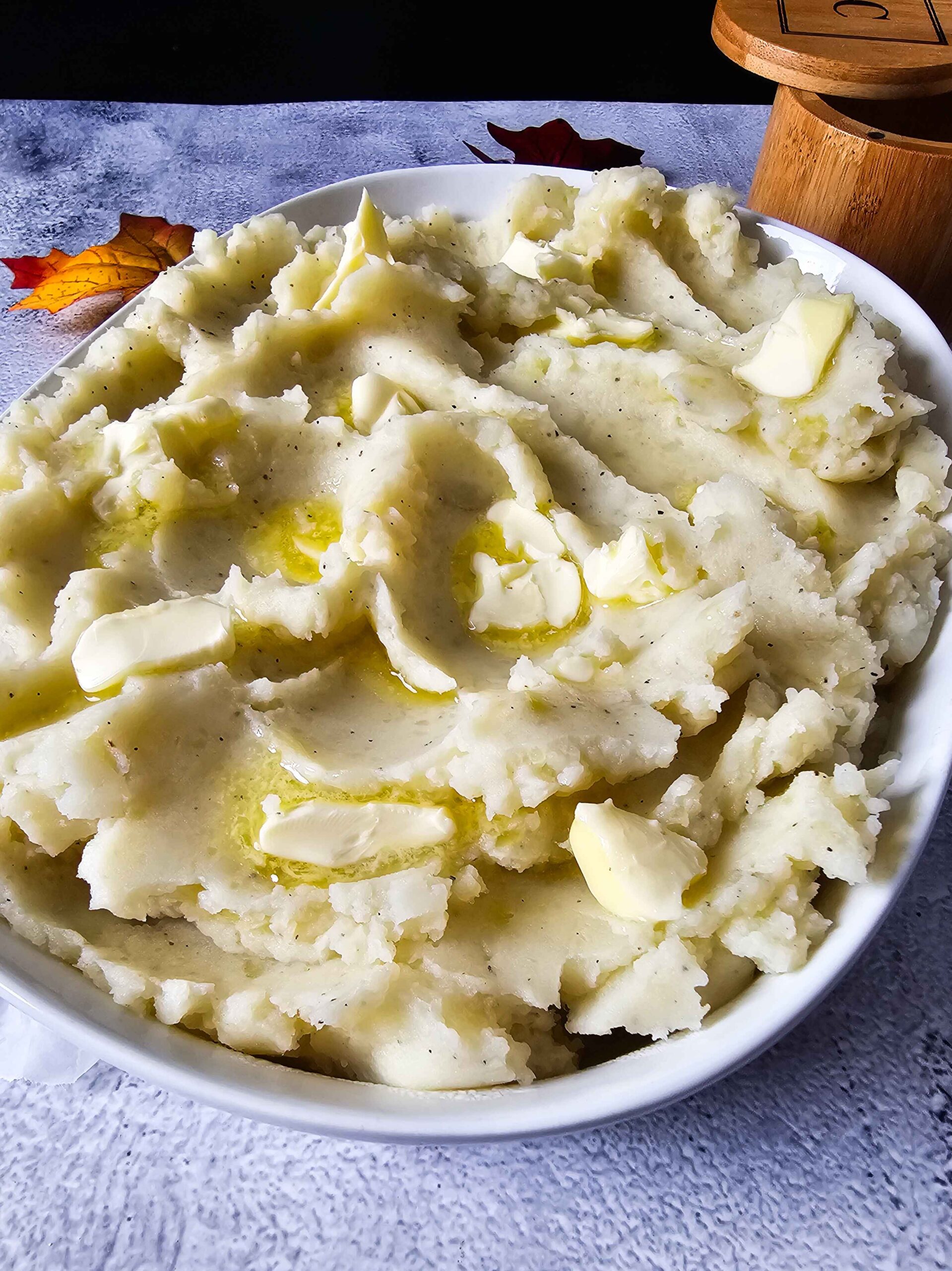 POTATOES IN CASSEROLE DISH AND DOTTED WITH BUTTER