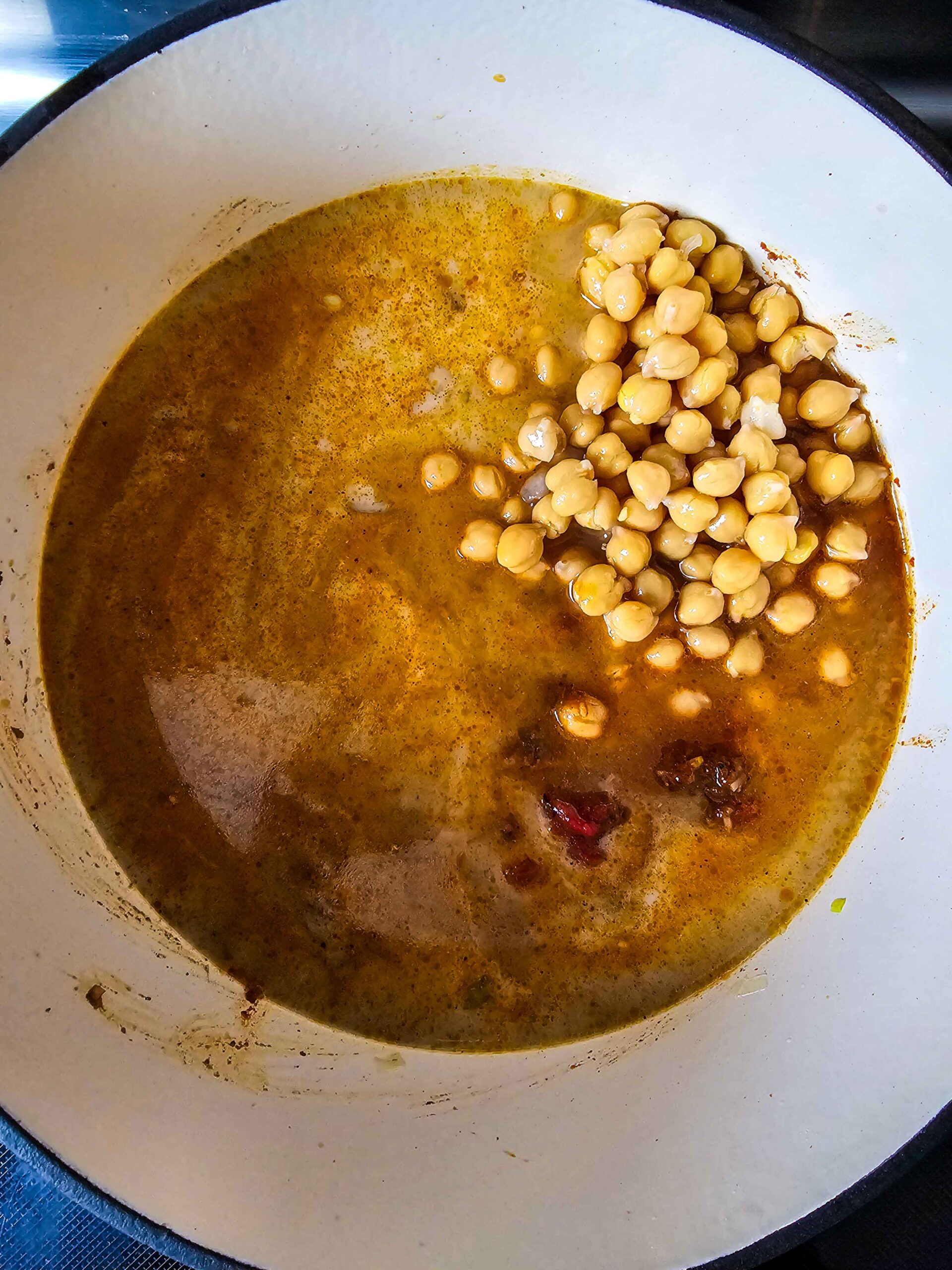 ADD THE TOMATOES, COCONUT MILK, AND CHICKPEAS