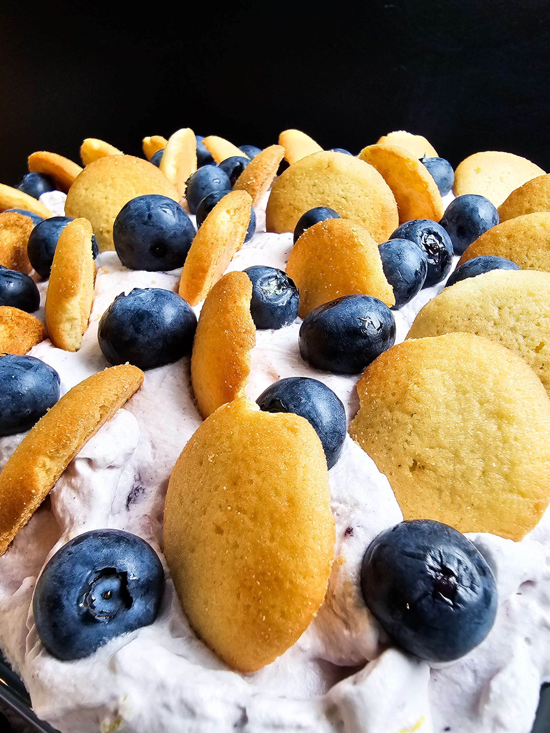TOP THE CAKE WITH LEFTOVER VANILLA WAFERS AND FRESH BLUEBERRIES