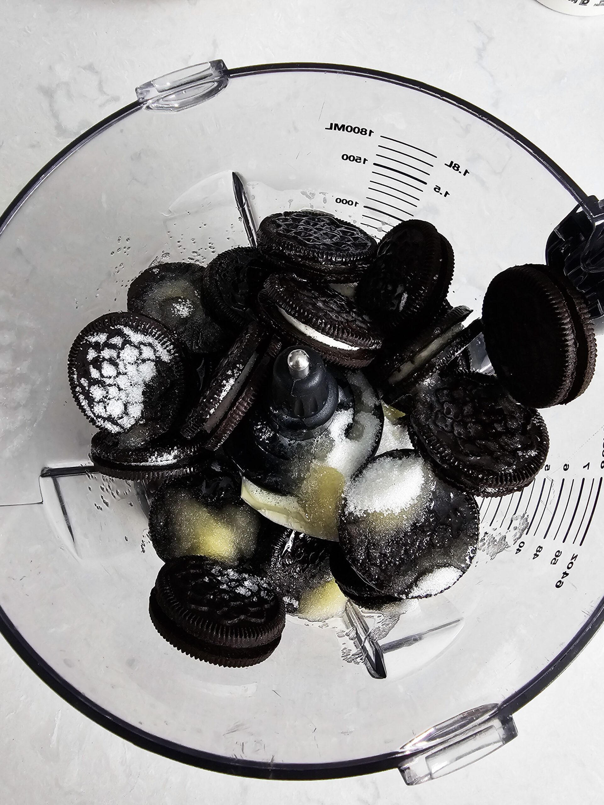 COMBINE THE BUTTER, SUGAR AND OREO COOKIES TO A FOOD PROCESSOR AND BLEND