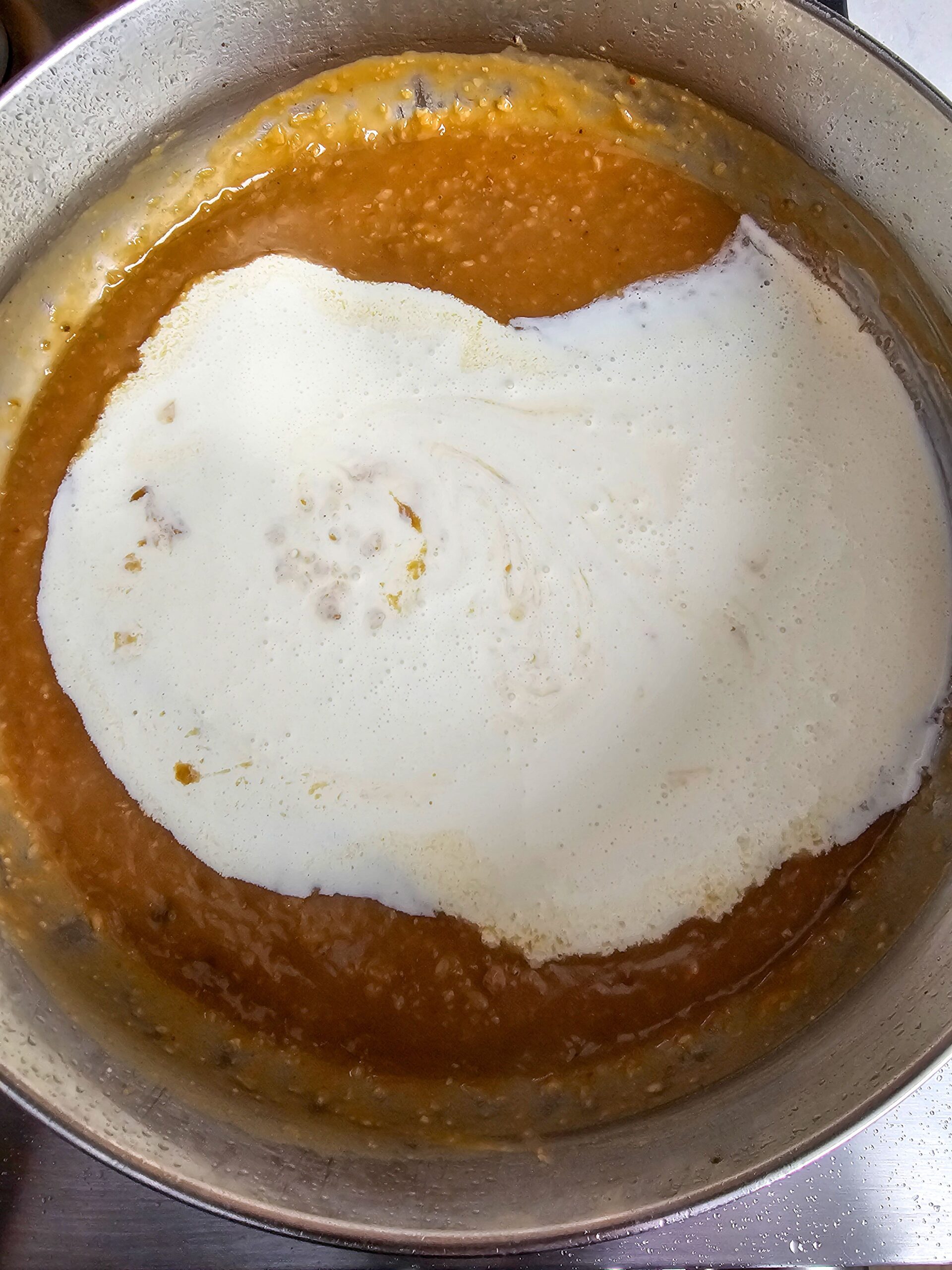 ADD THE CHICKEN STOCK AND HEAVY CREAM TO THE POT WHISK UNTIL SMOOTH