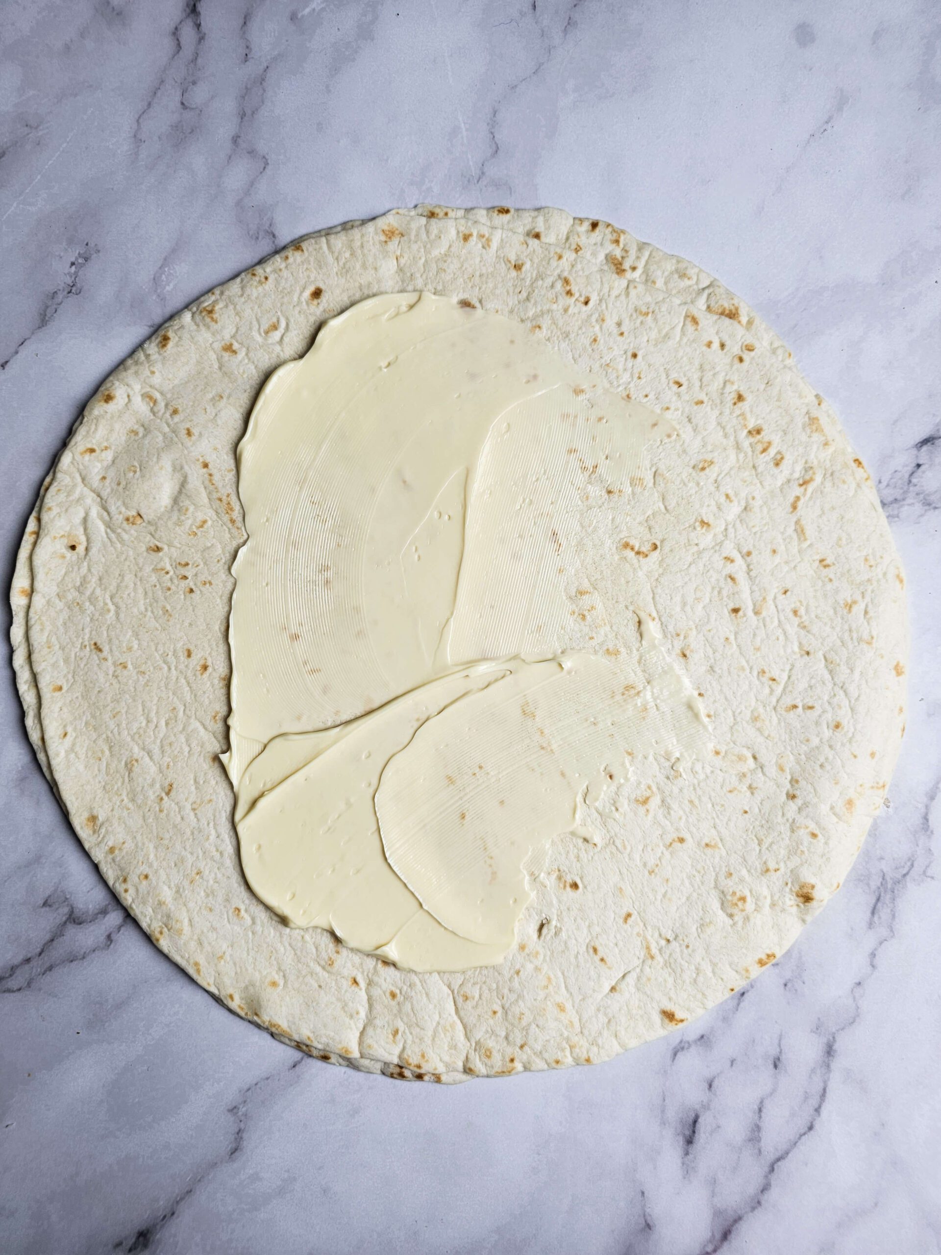 SPREAD THE MAYO ON THE TORTILLA