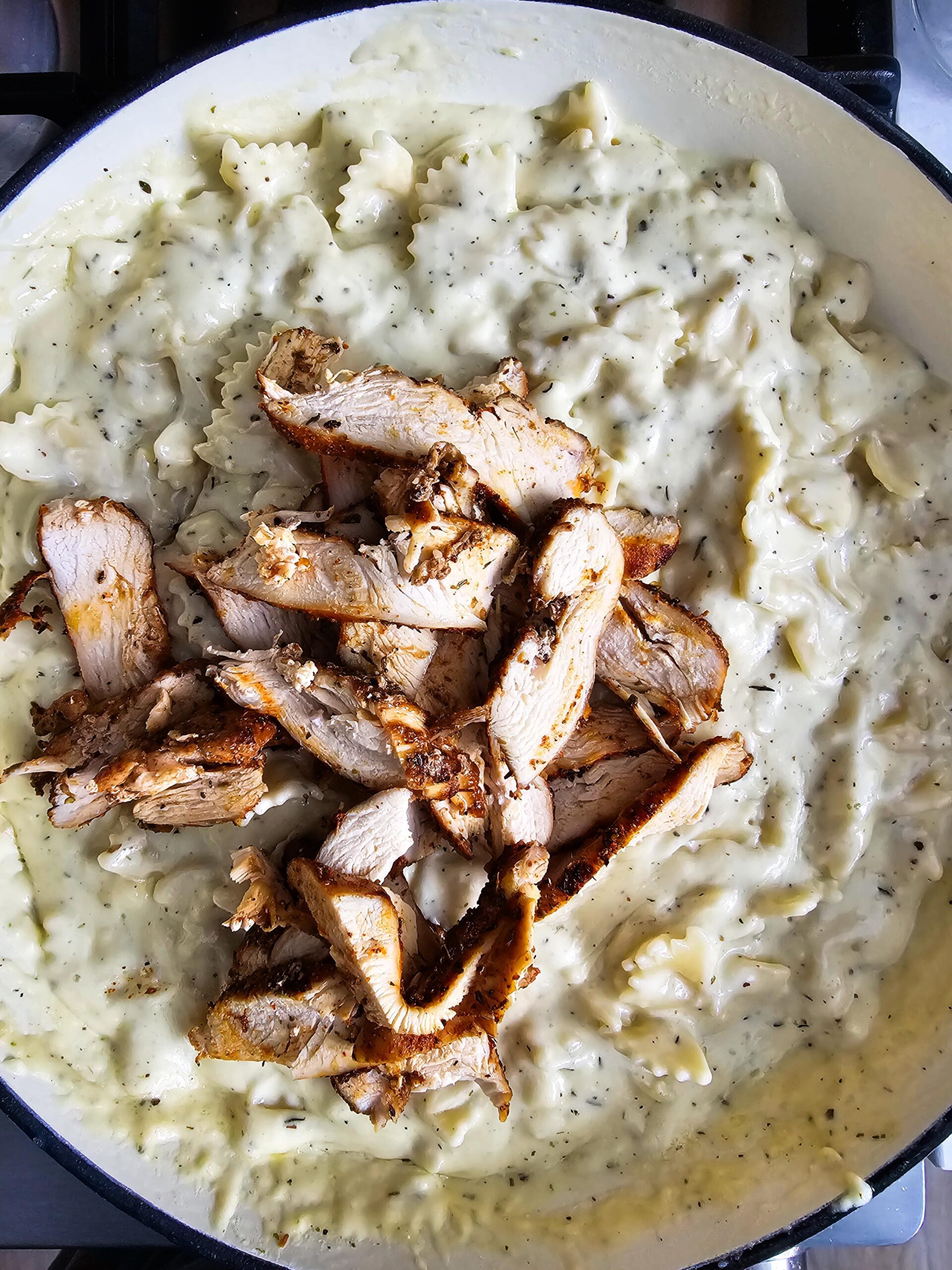 ADD THE PASTA AND SLICED CHICKEN BREAST TO THE SAUCE AND WARM SLOWLY